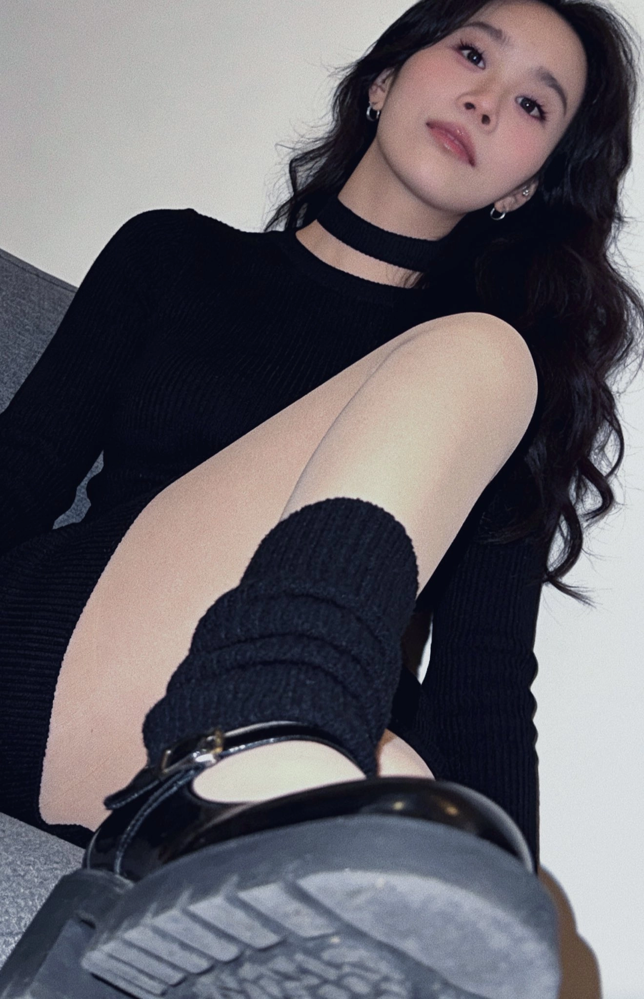 穿着黑色衬衫和黑色衬衫的女人坐在沙发上。