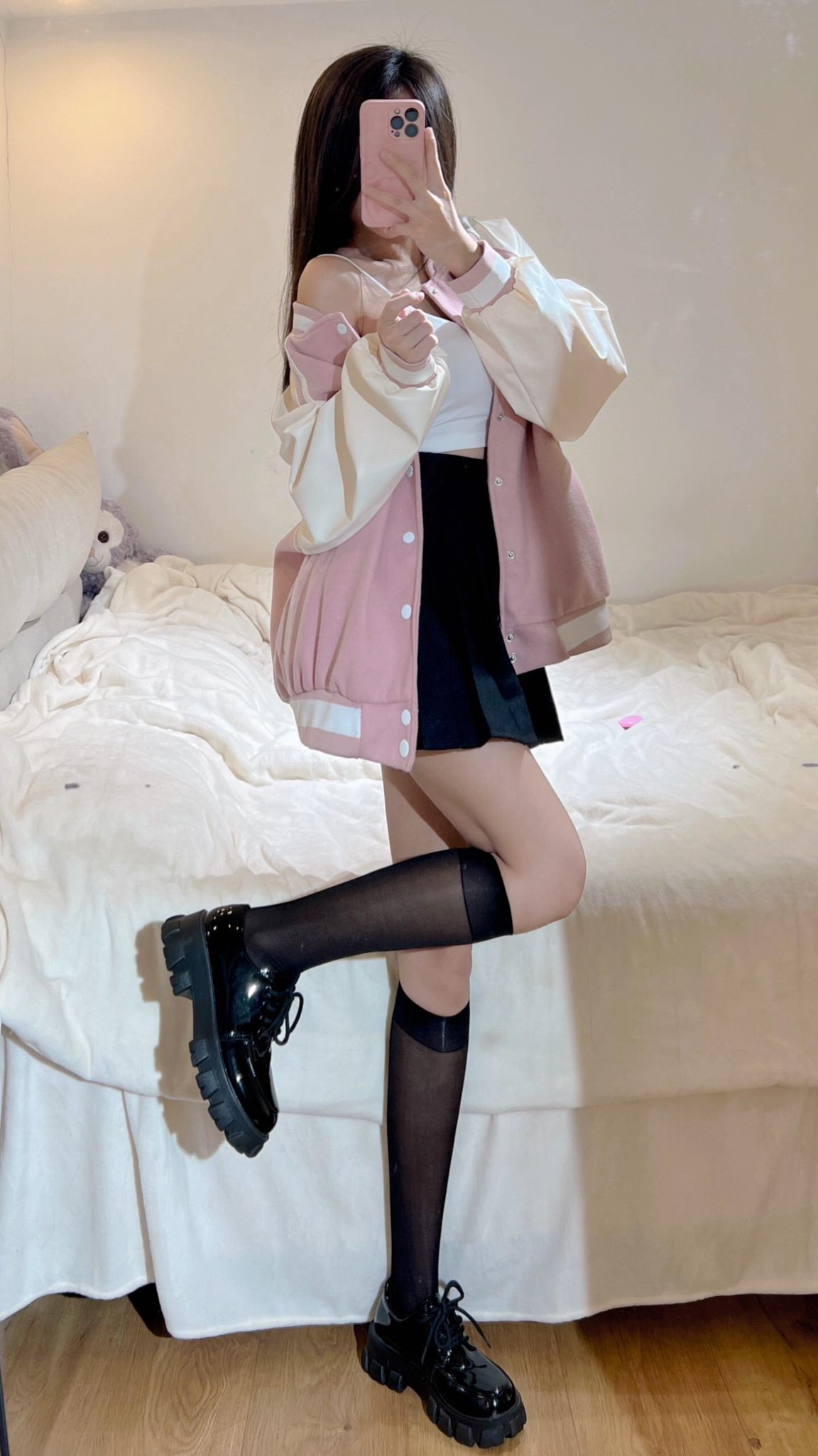 穿着粉红色夹克和黑色裙子的女孩拿着一把玩具枪。