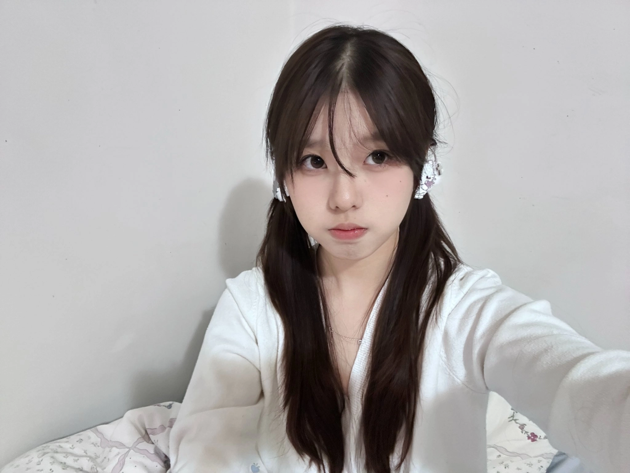 长头发和马尾巴的女孩穿着一件白色衬衫和耳机。