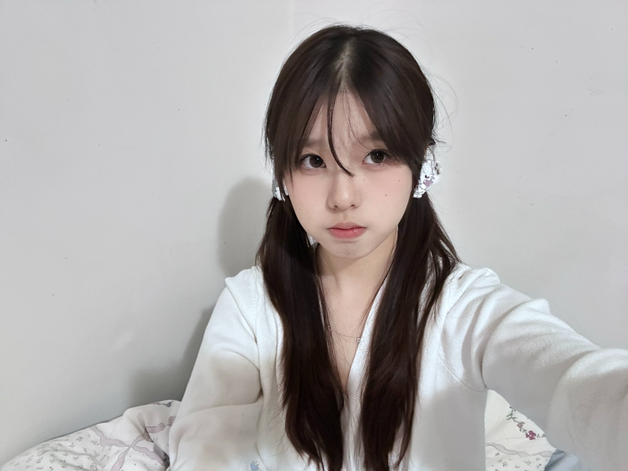 长头发和马尾巴的女孩穿着一件白色衬衫和耳机。