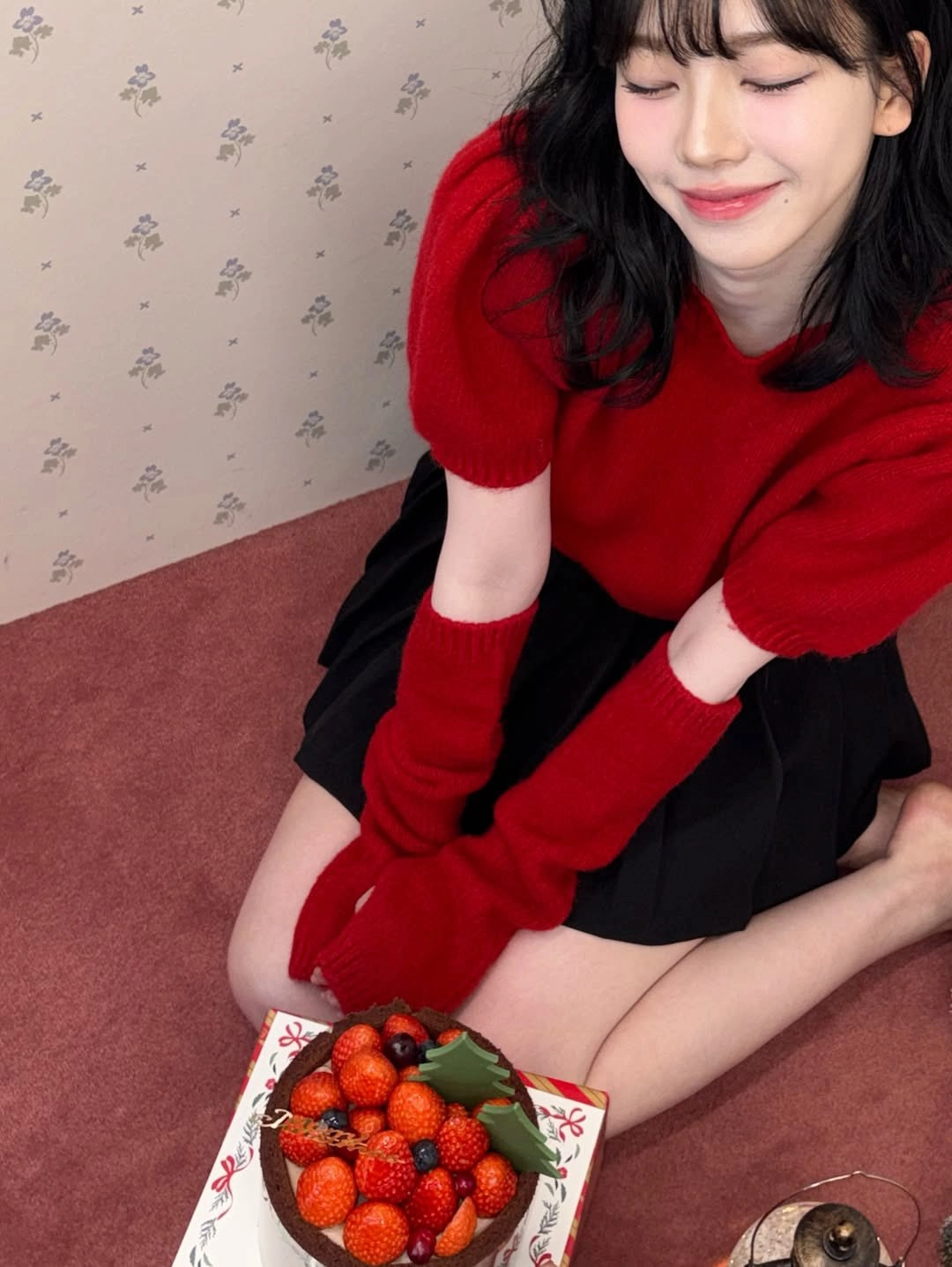 穿着红色衬衫和黑色衬衫的女人坐在地板上。