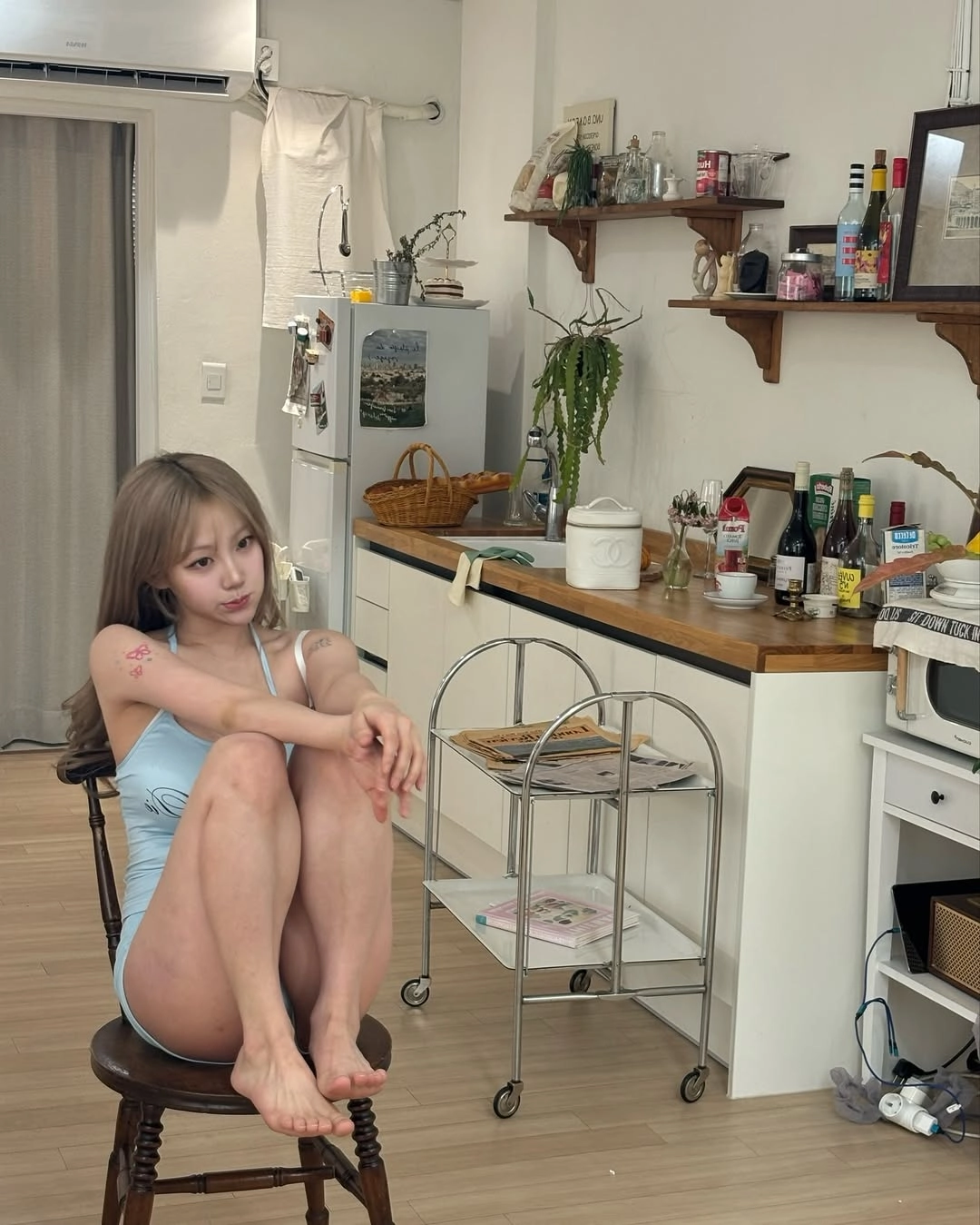 女孩坐在厨房里的椅子上。