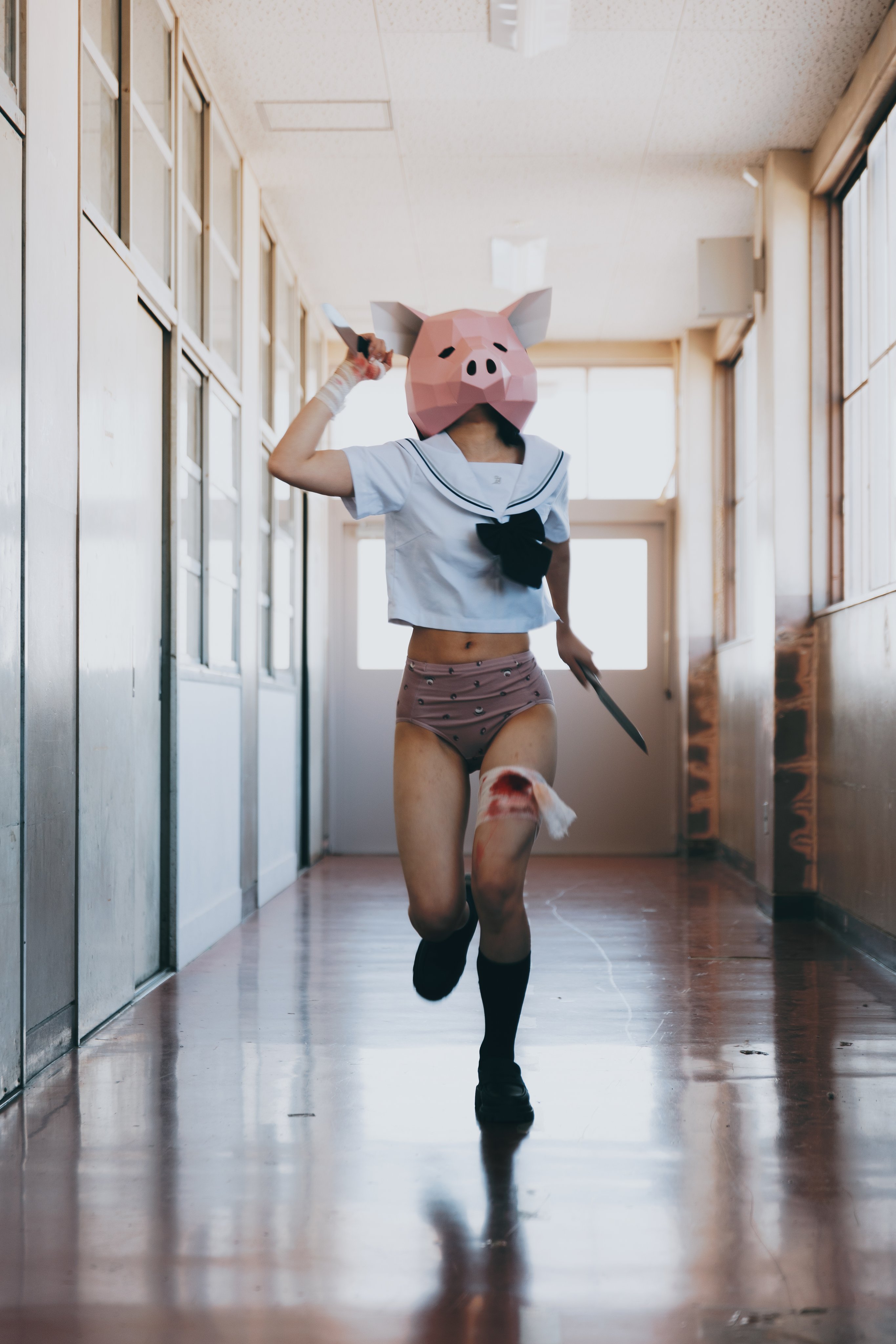 戴着猪面具的女孩坐在桌子上。