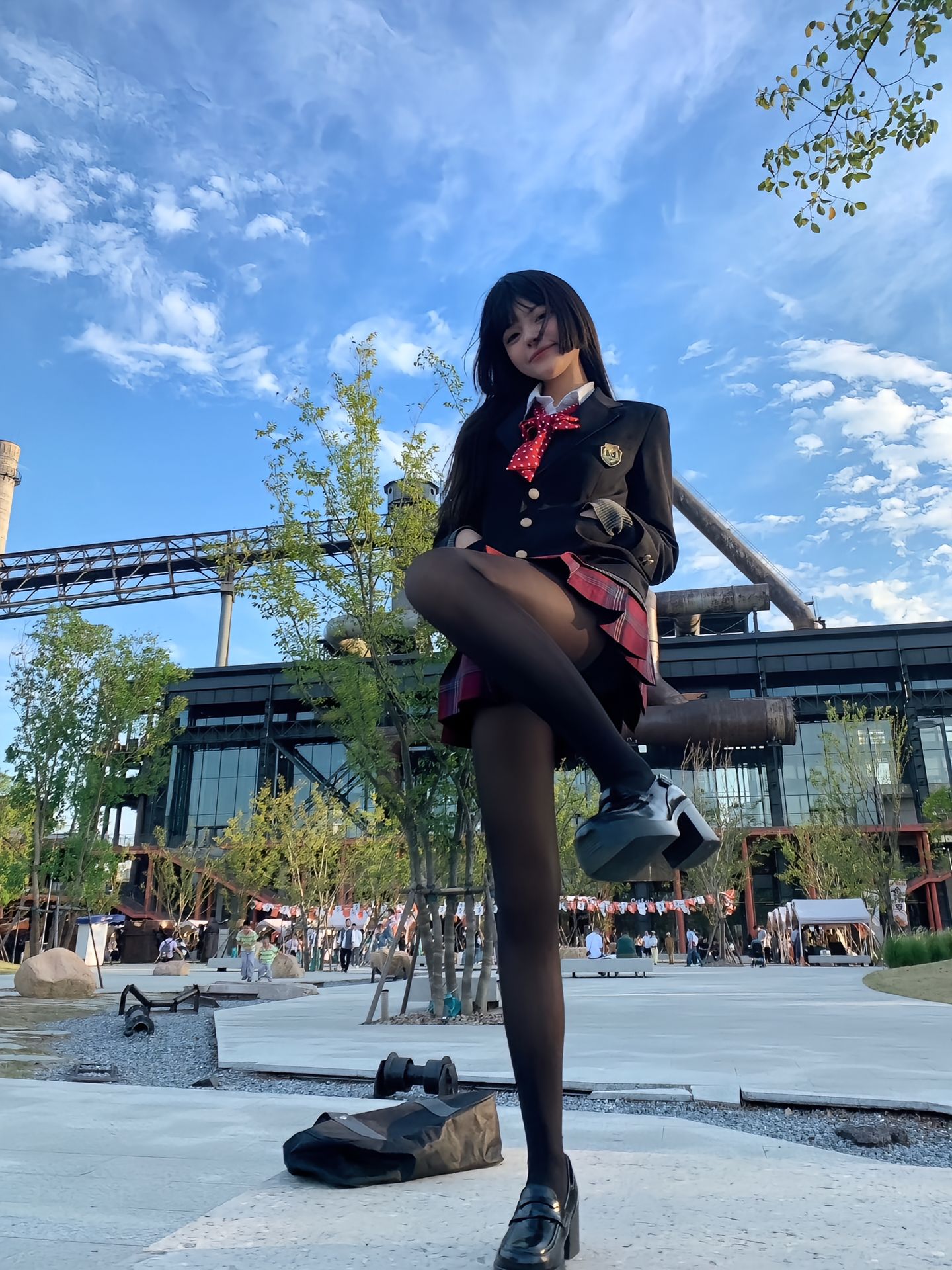 穿着学校制服的女孩站在滑板上。