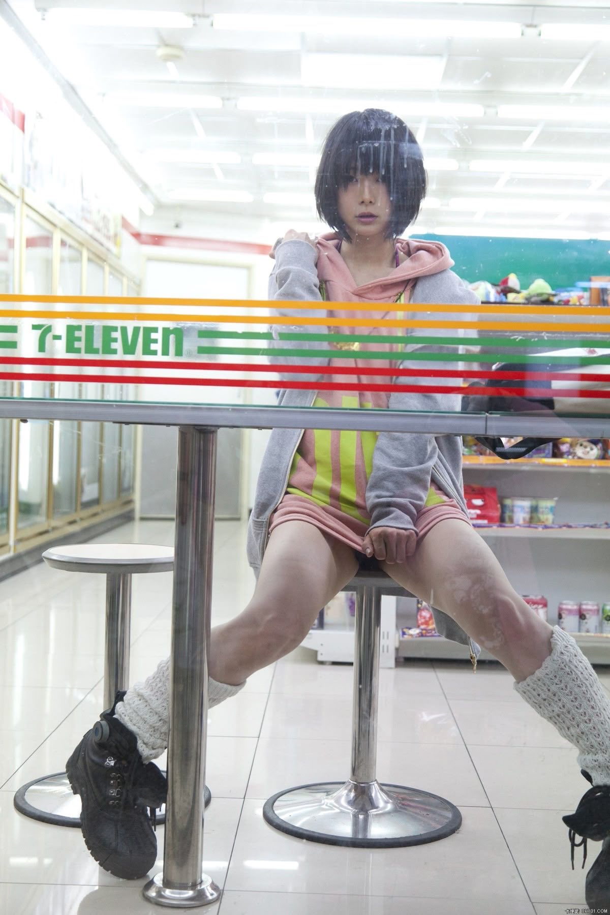 女人坐在一把椅子上,站在一个七十一符号前面。