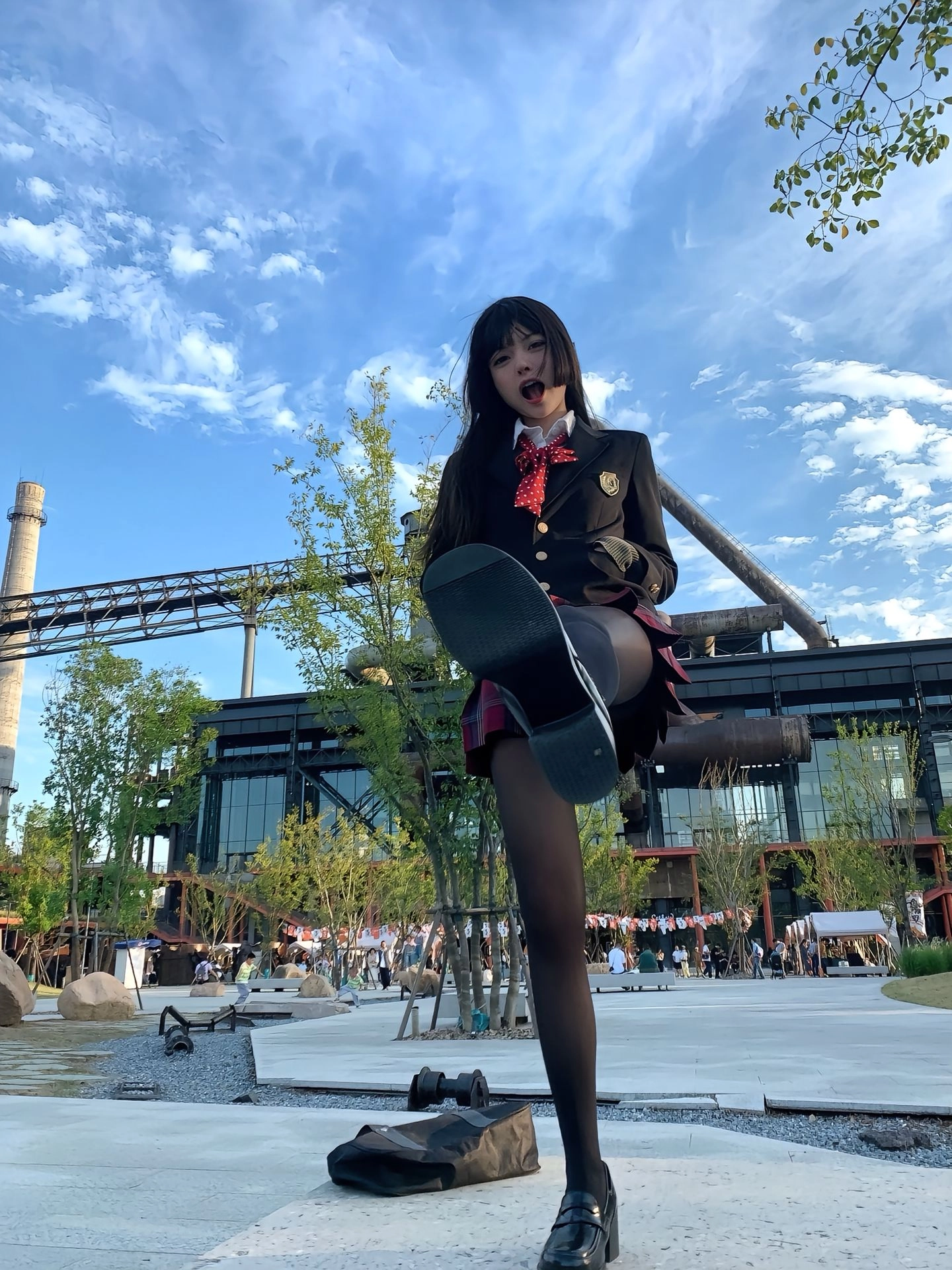 穿着学校制服的女孩站在滑板上。