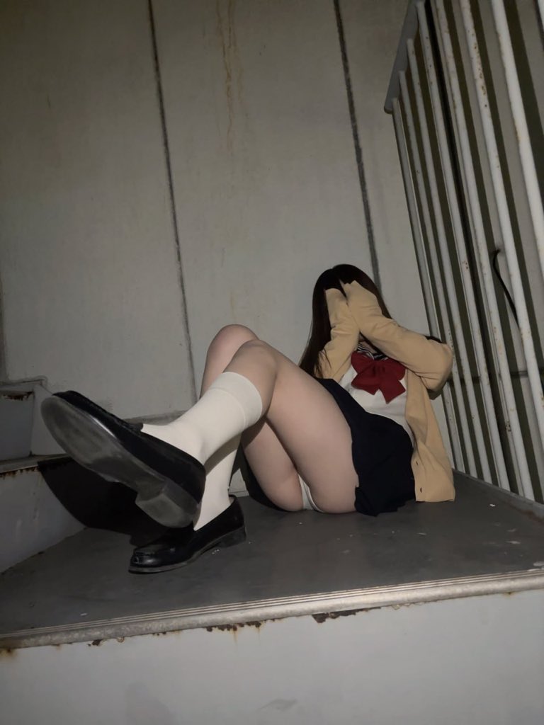 穿着裙子和红弓的女人坐在楼梯上。