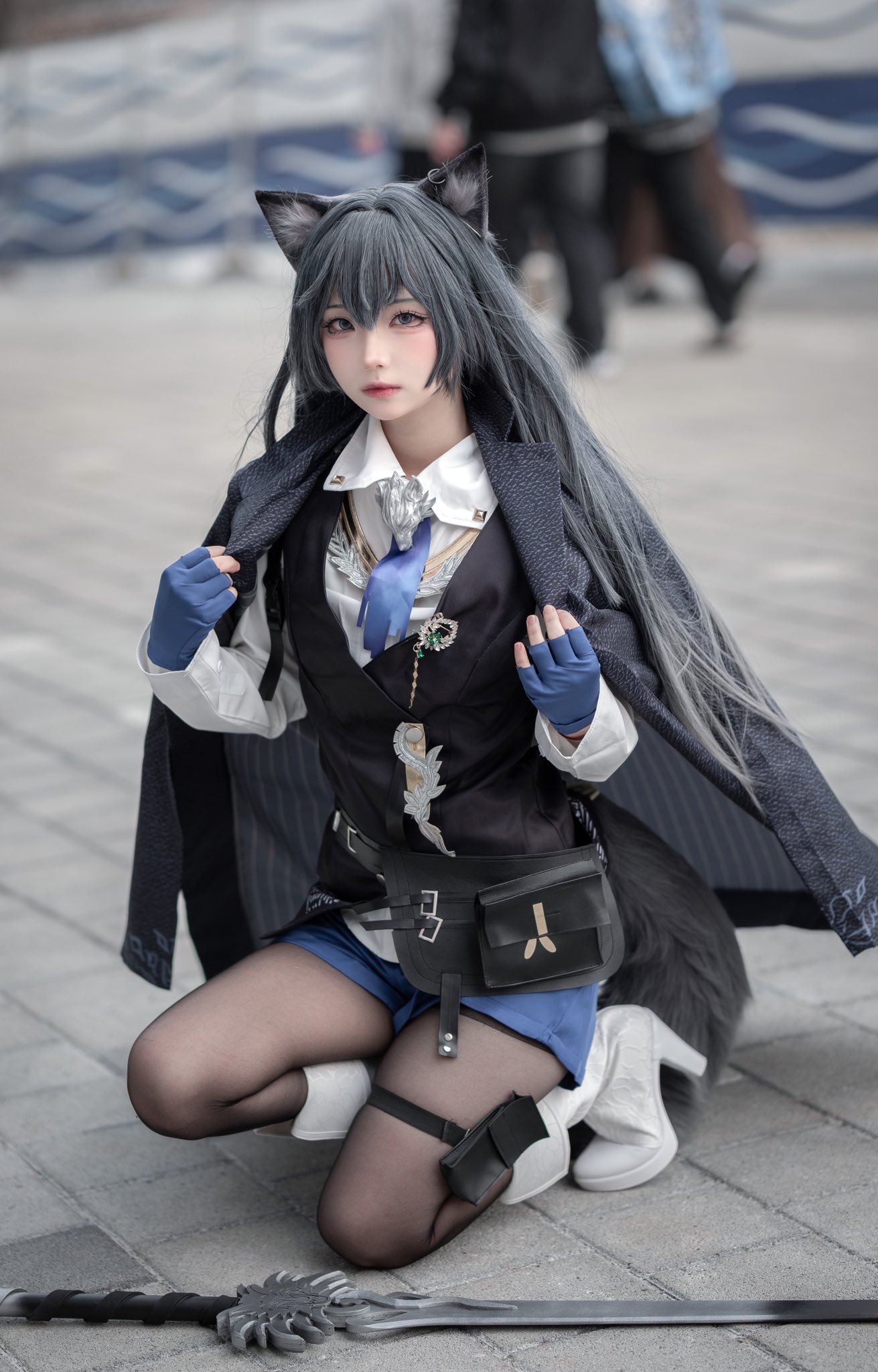 女人穿着一个黑色和蓝色的服装,有一条狐狸尾巴。