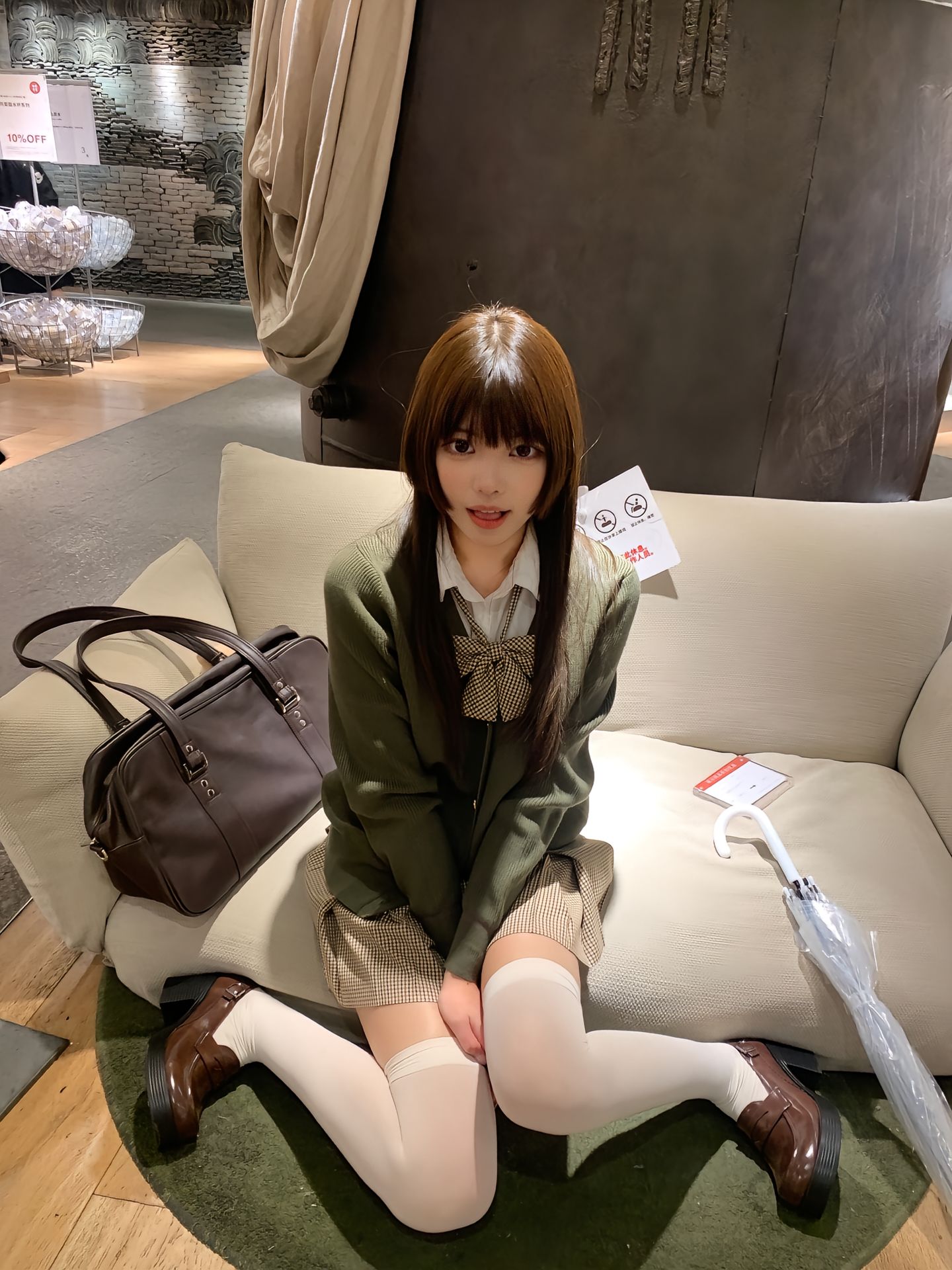 女人坐在沙发上,带着一个钱包和伞。