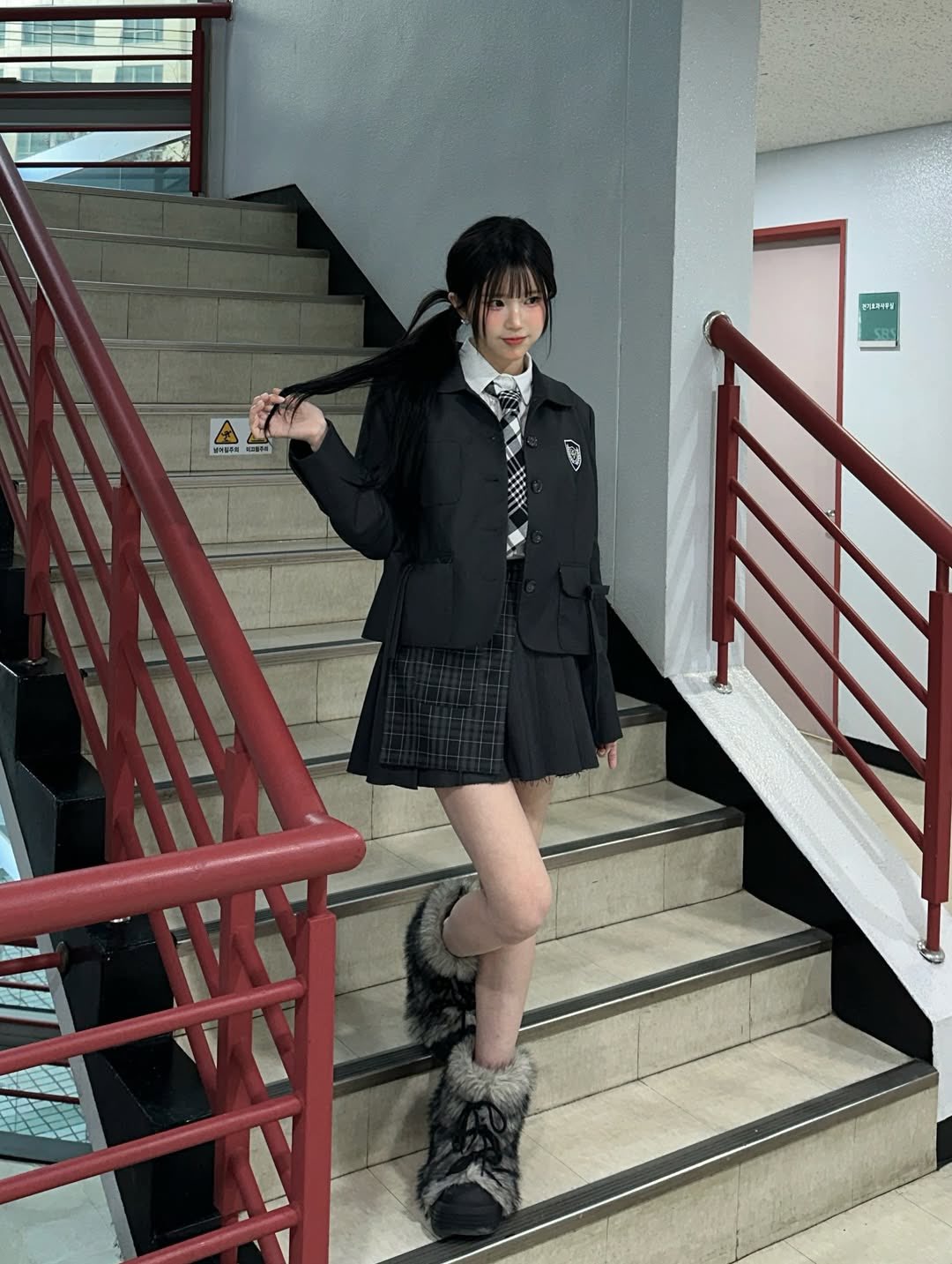 穿着黑白裙子的女孩站在楼梯上。