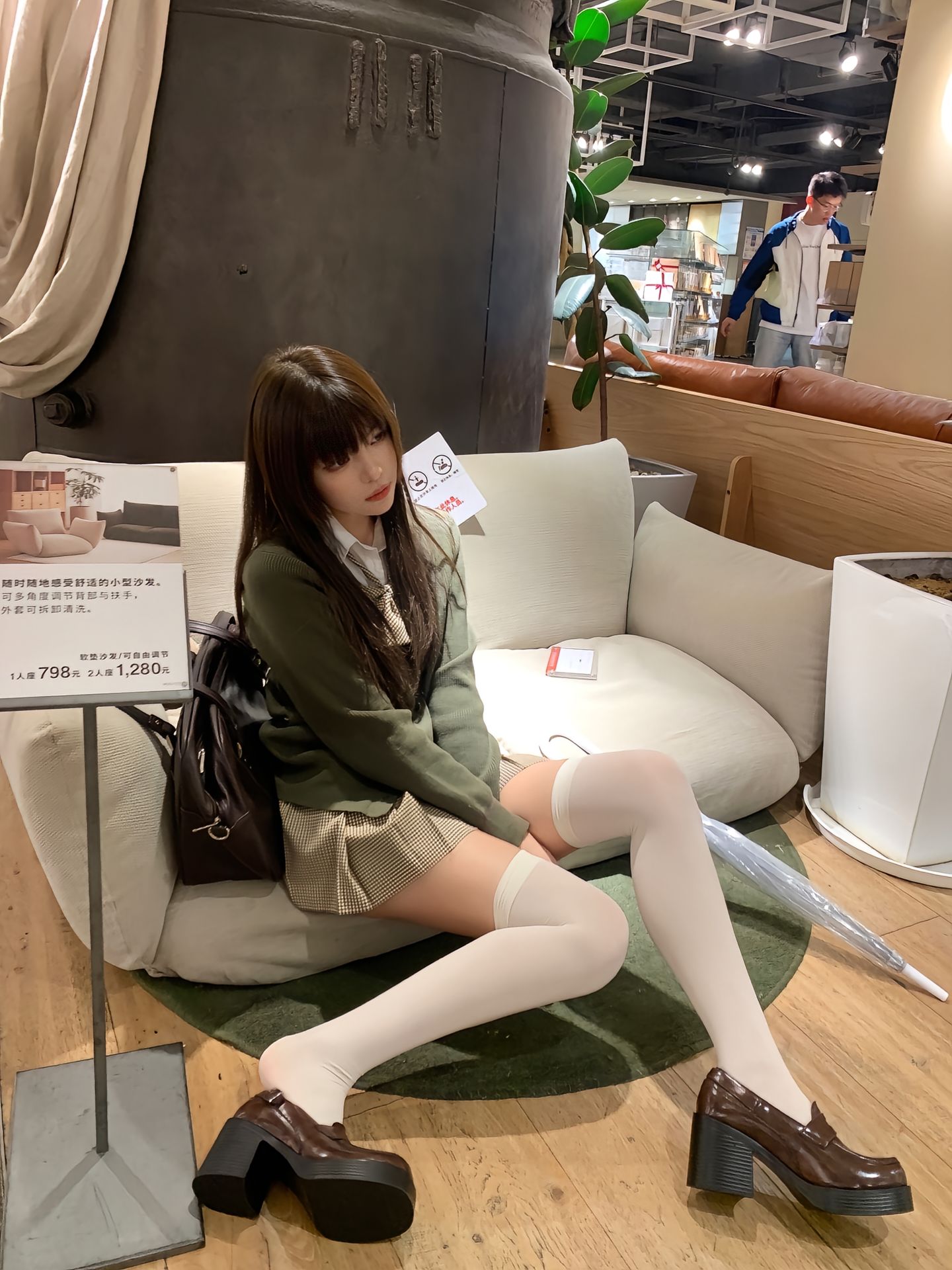 女人坐在沙发上,带着一个钱包和伞。