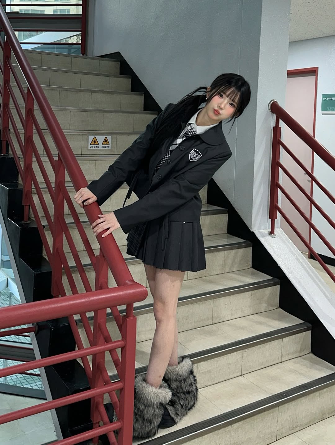 穿着黑白裙子的女孩站在楼梯上。