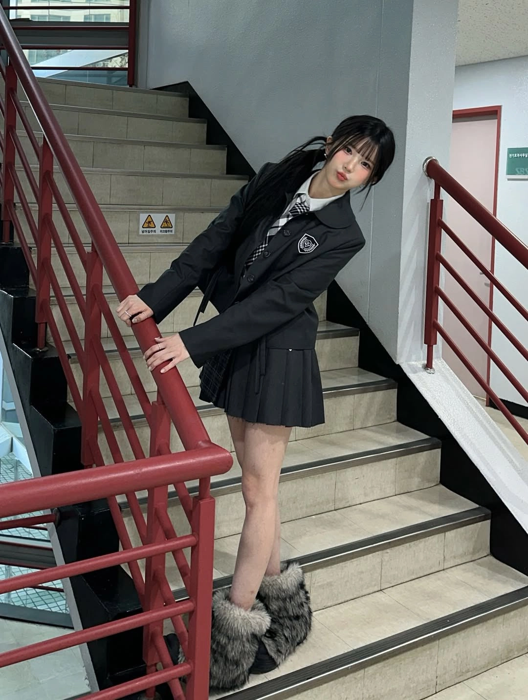 穿着黑白裙子的女孩站在楼梯上。