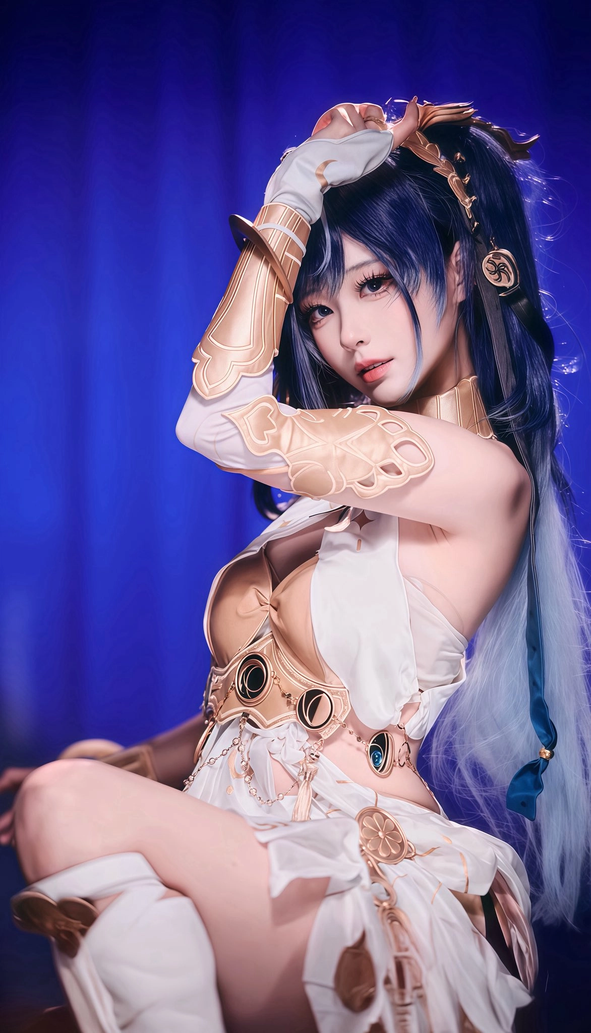 一位身穿金盔的白色裙子和蓝色头发的女人为一张照片。