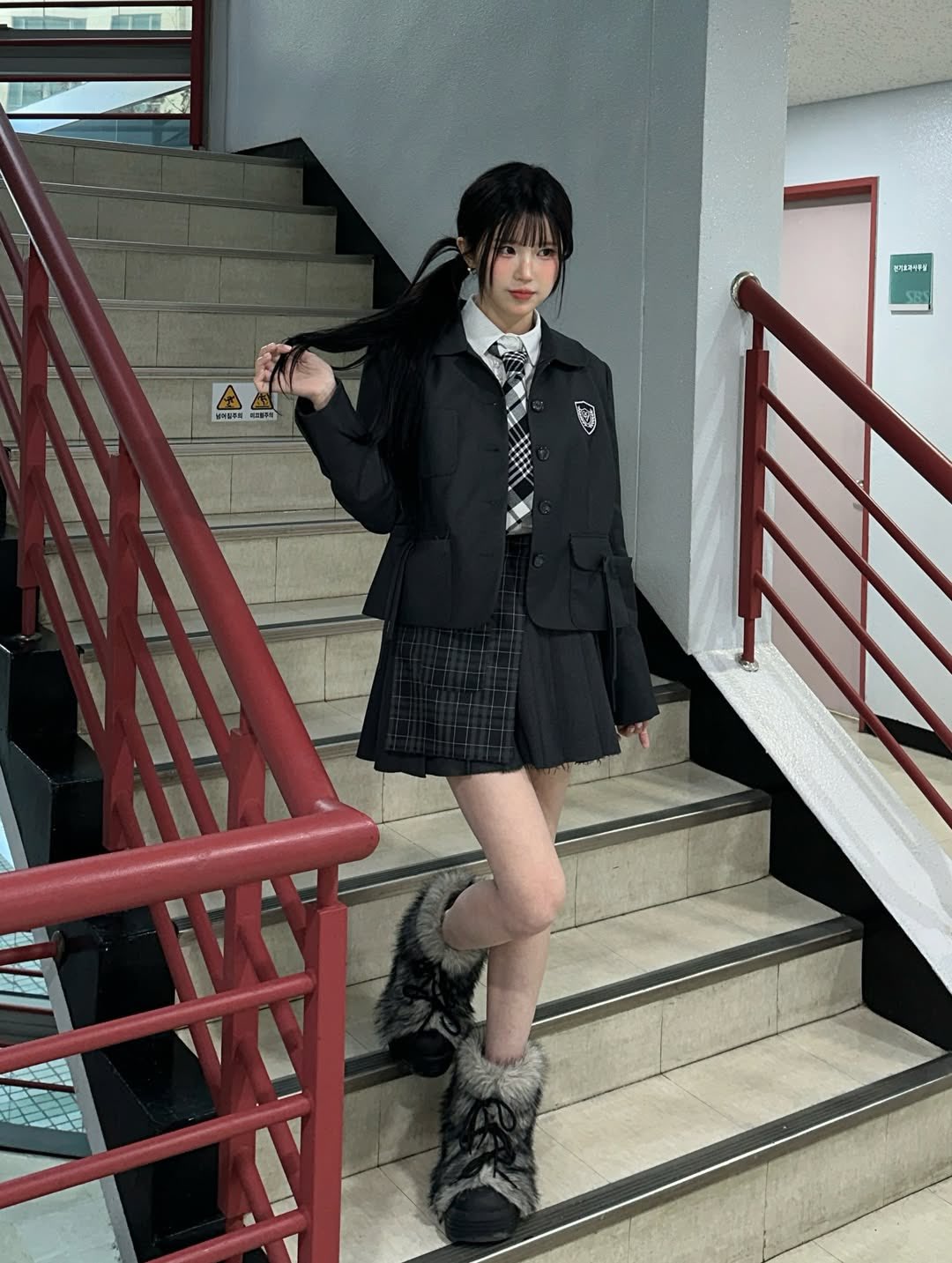 穿着黑白裙子的女孩站在楼梯上。