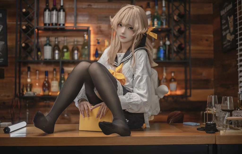 女人坐在一张桌子上,她面前有一个盒子。