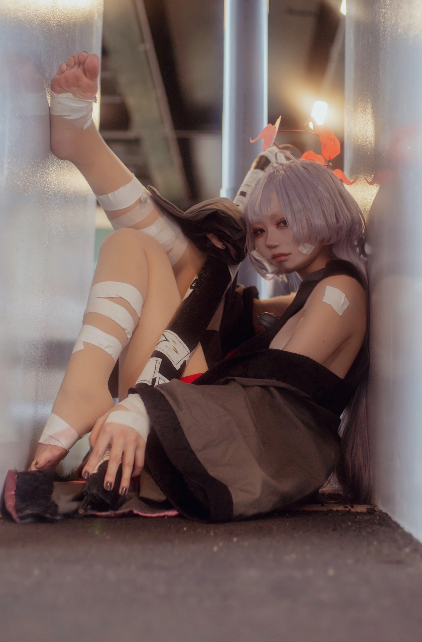 穿着黑色衬衫和白头发的女人坐在地上。