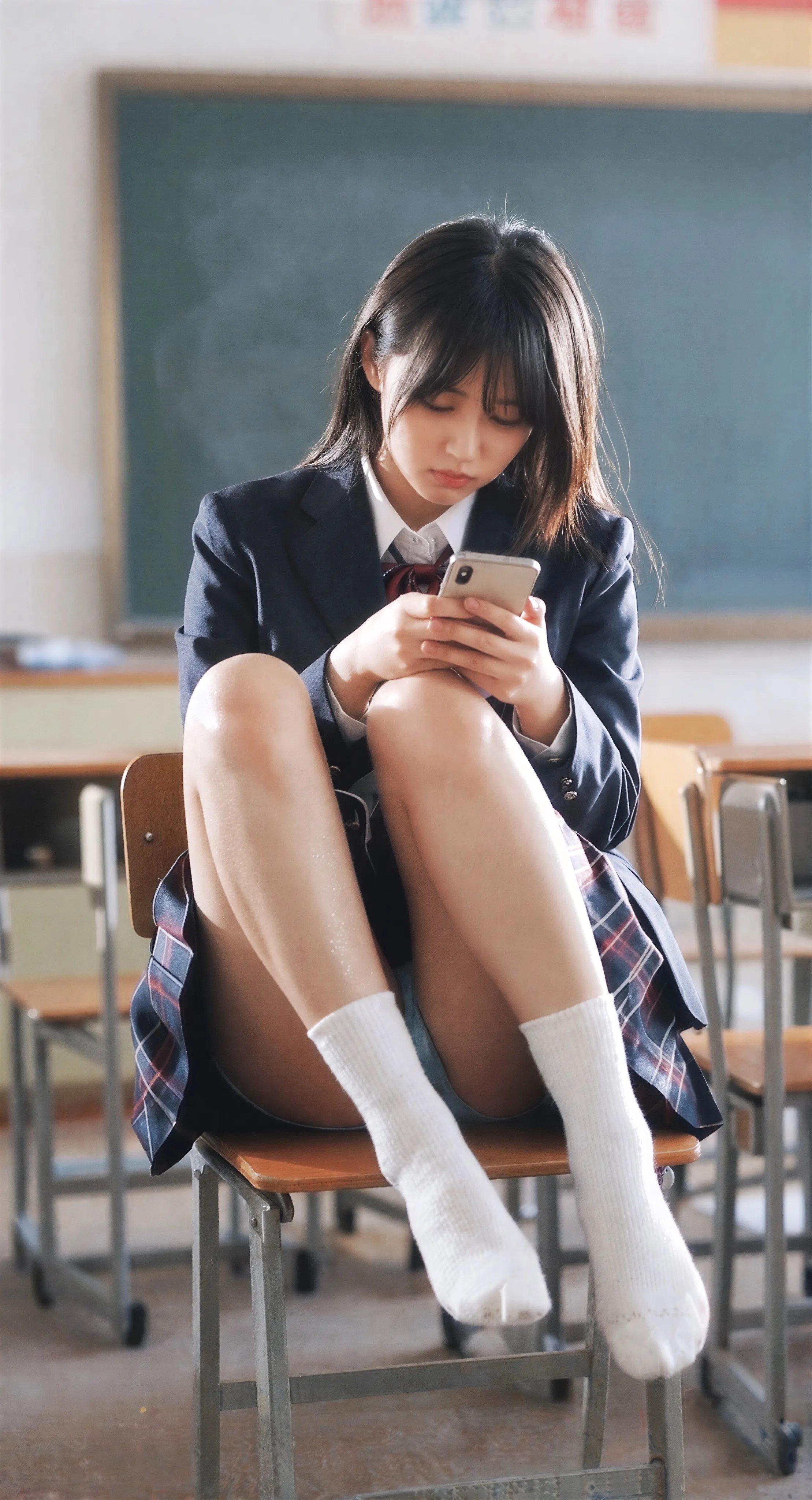 一名穿着校服的女孩正在检查她的手机。