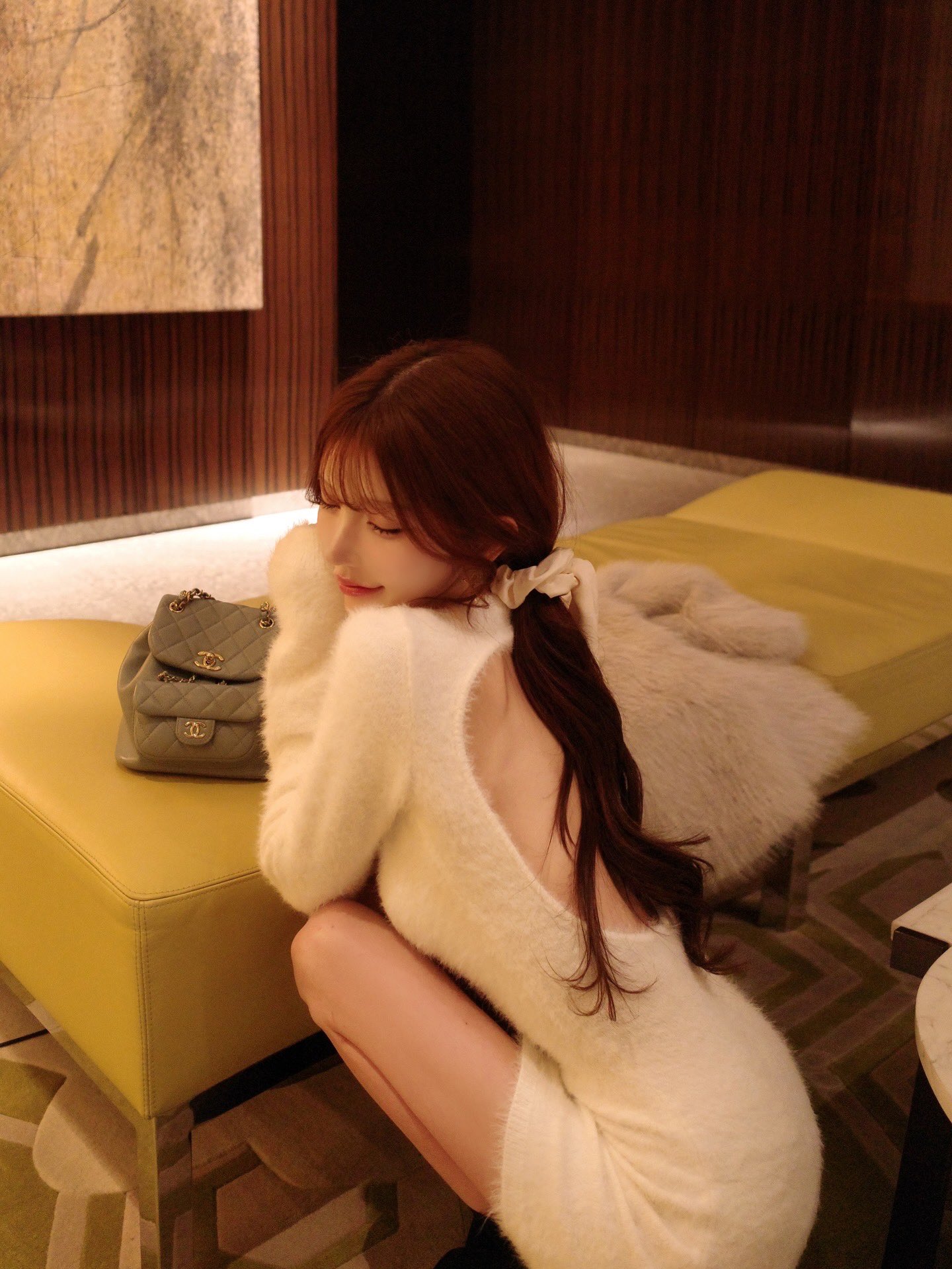 穿白色衬衫的女人坐在沙发上。