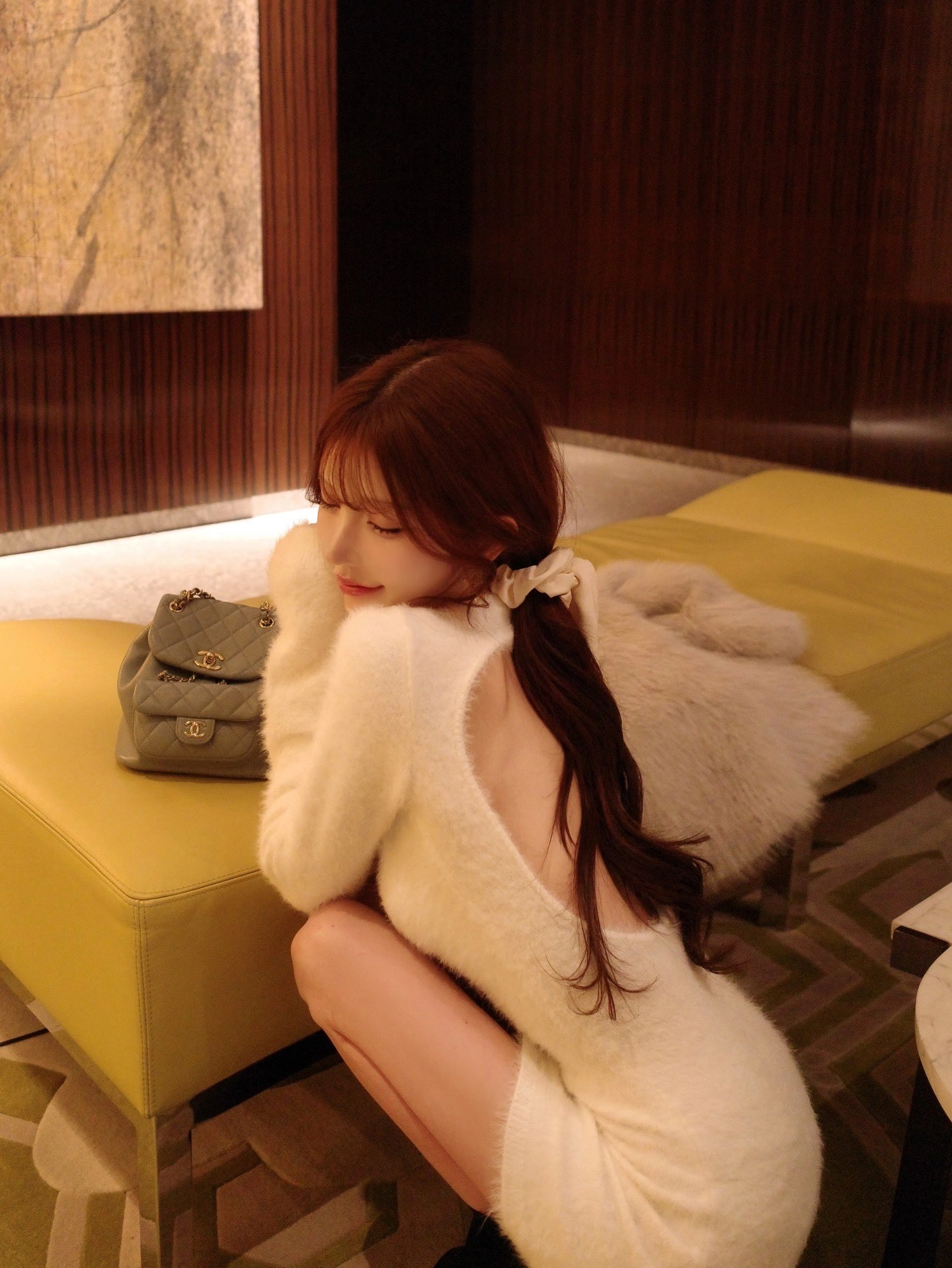 穿白色衬衫的女人坐在沙发上。