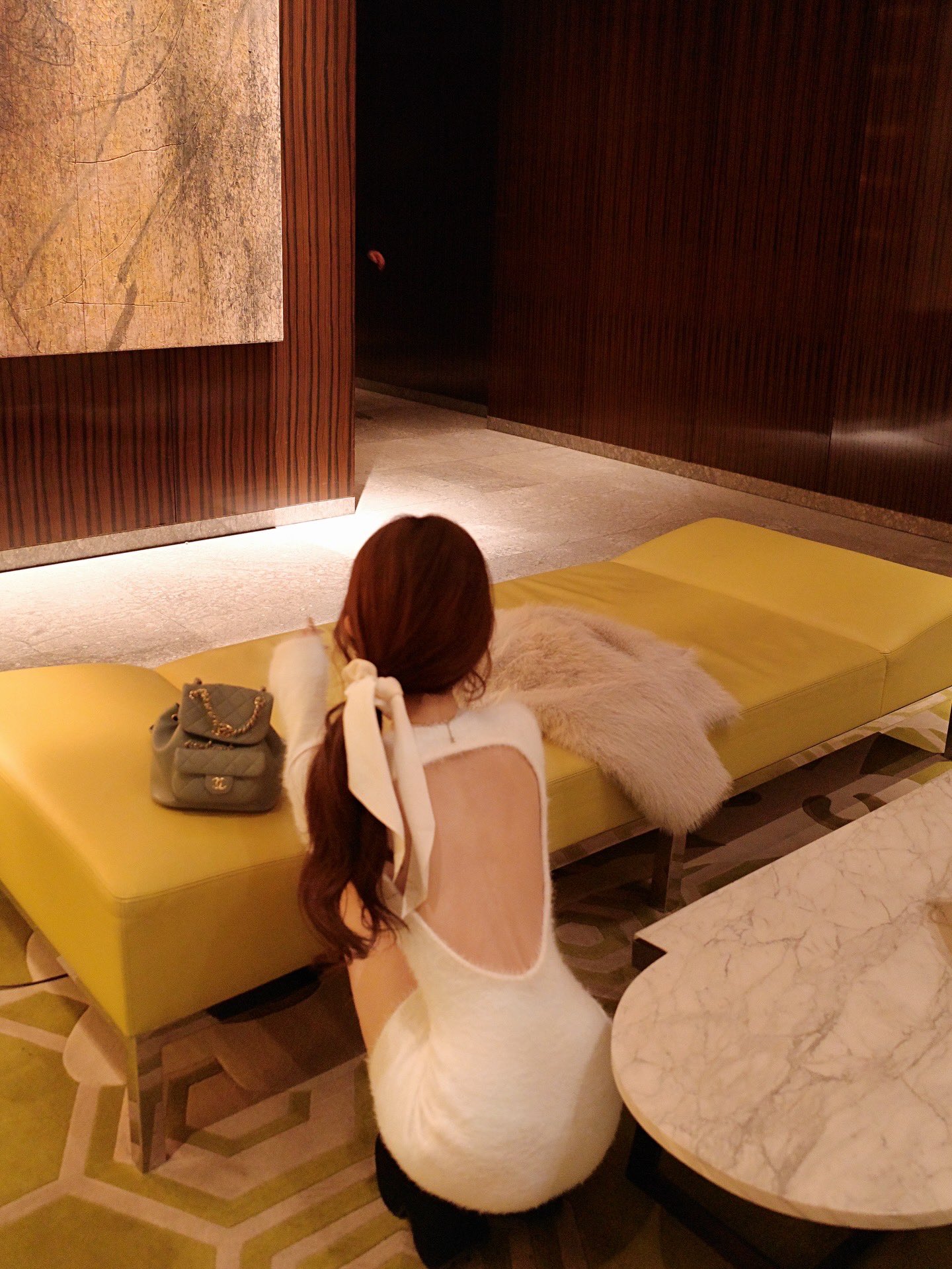 穿白色衬衫的女人坐在沙发上。