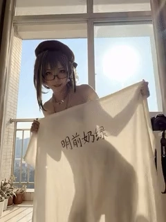 戴着眼镜和一顶帽子的女人站在窗前。