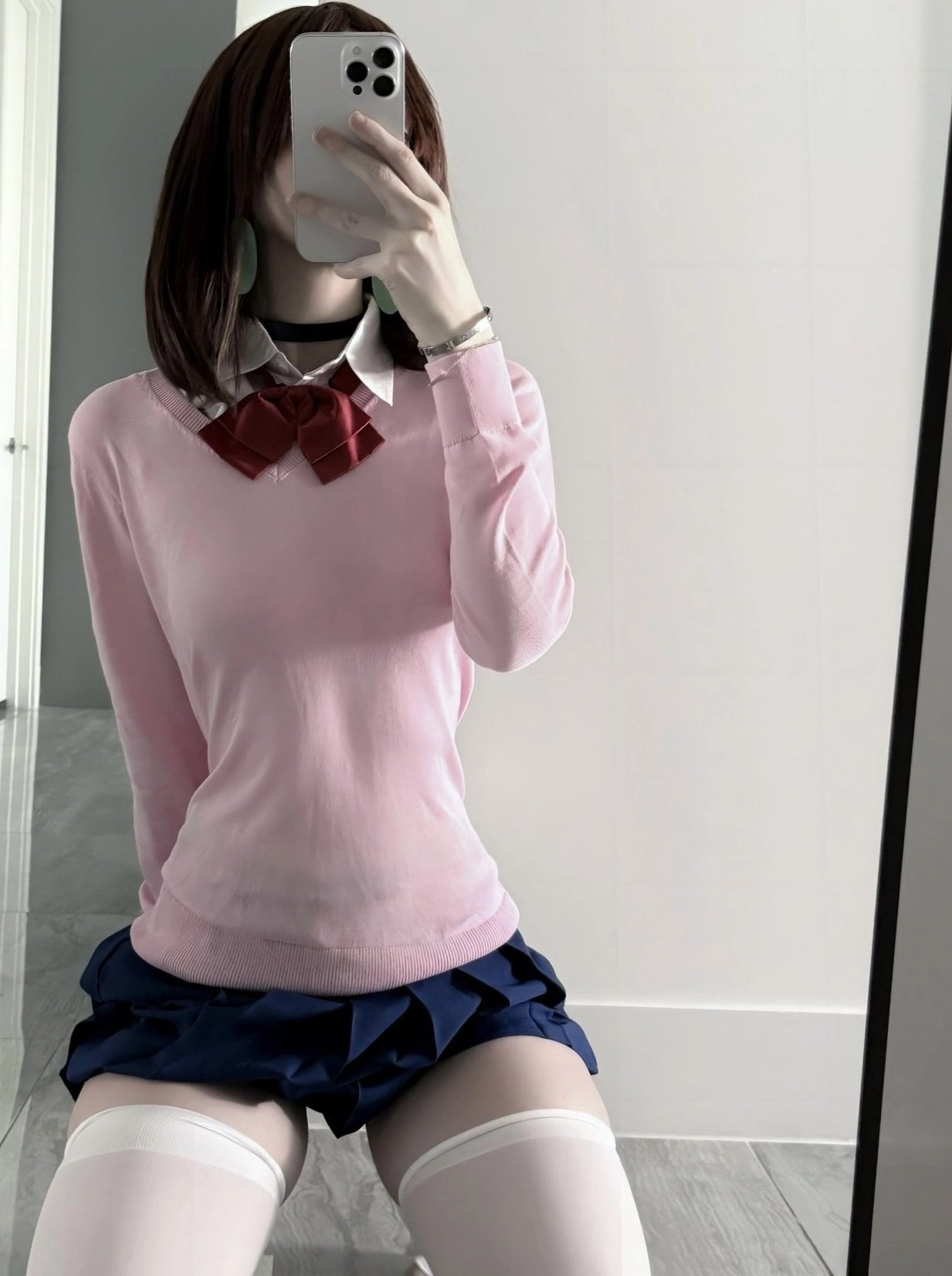 女人用粉红色衬衫和蓝色裙子拍自拍。