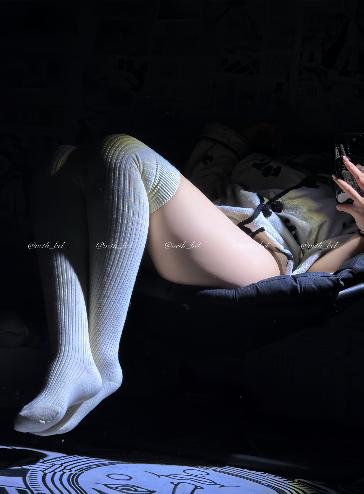 一位穿着白色衬衫和白袜子的女人躺在椅子上。