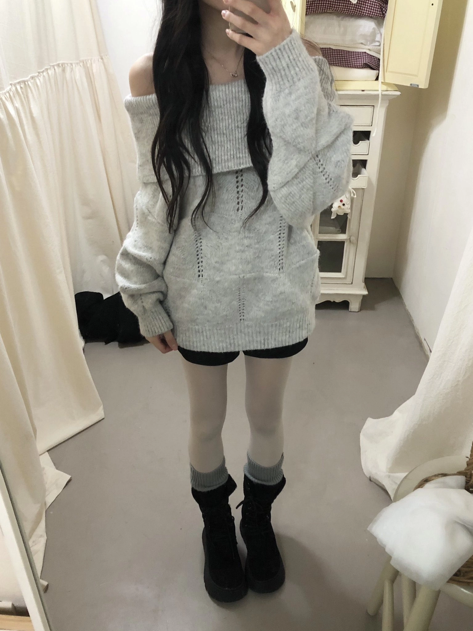 穿着灰色衬衫和黑色靴子的女人。