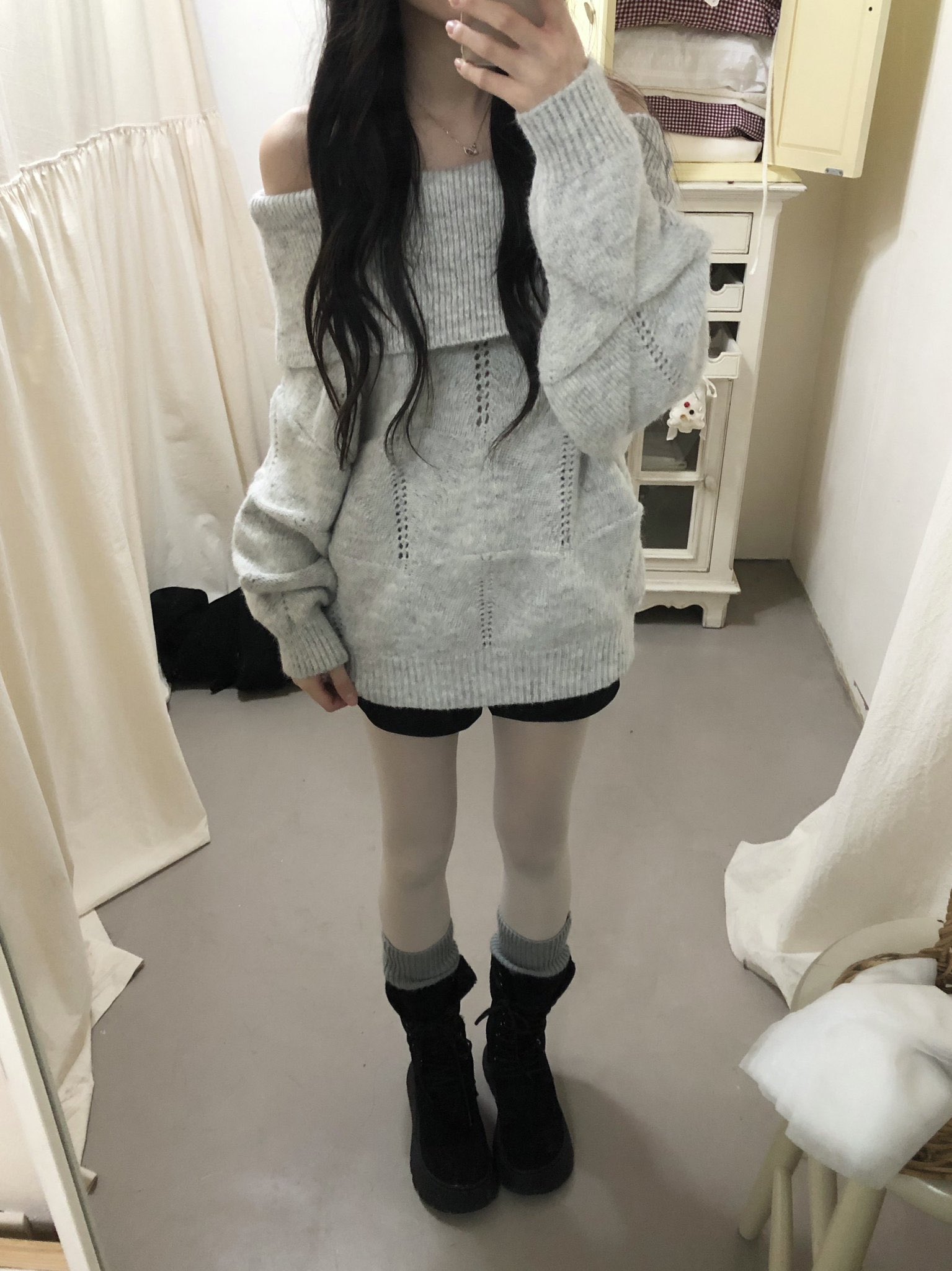 穿着灰色衬衫和黑色靴子的女人。