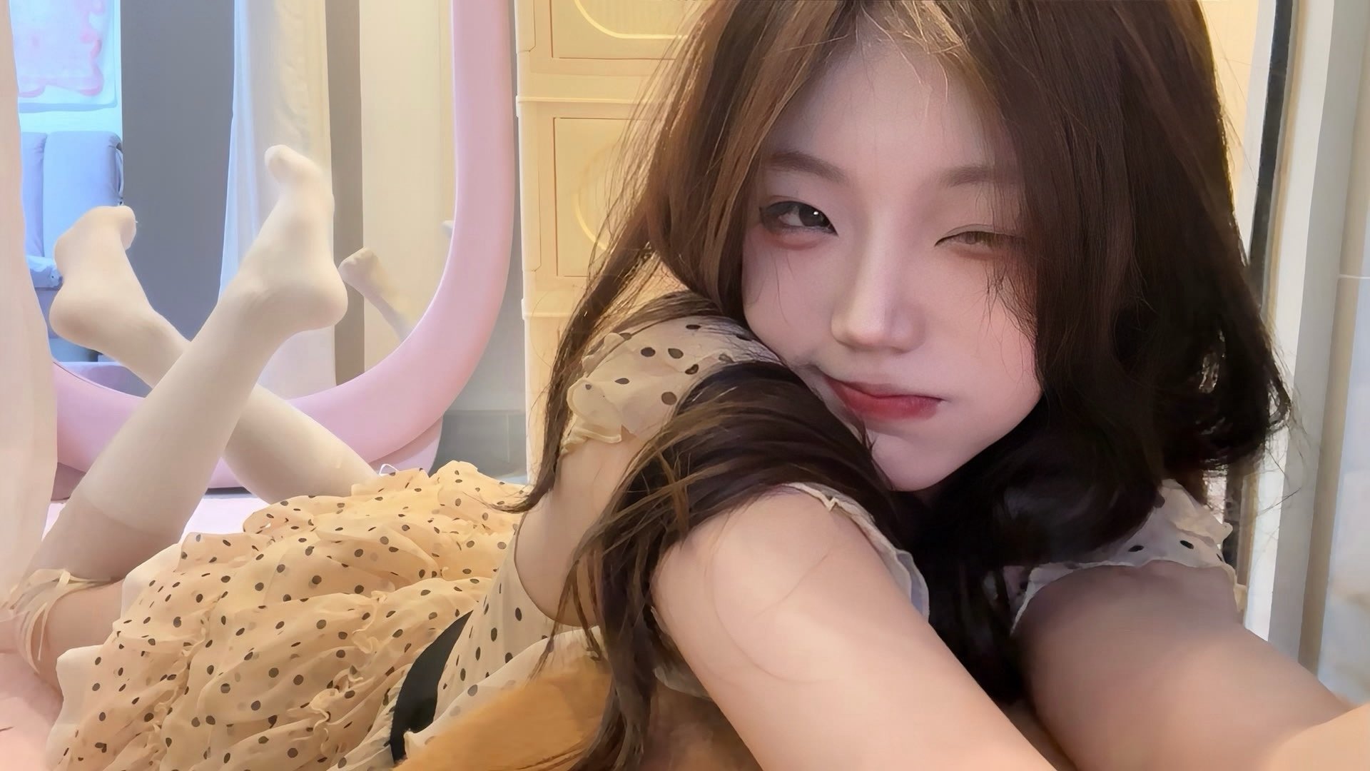 长头发和一个波尔卡点裙子的女人正在制作一个有趣的面孔。