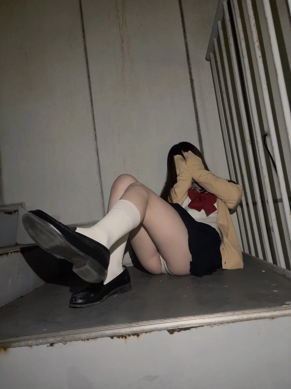 穿着学校制服的女人坐在楼梯上。