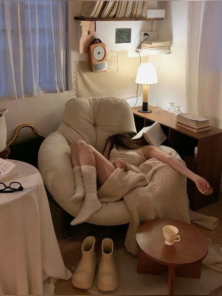 女人躺在椅子上,脸上有一本书。