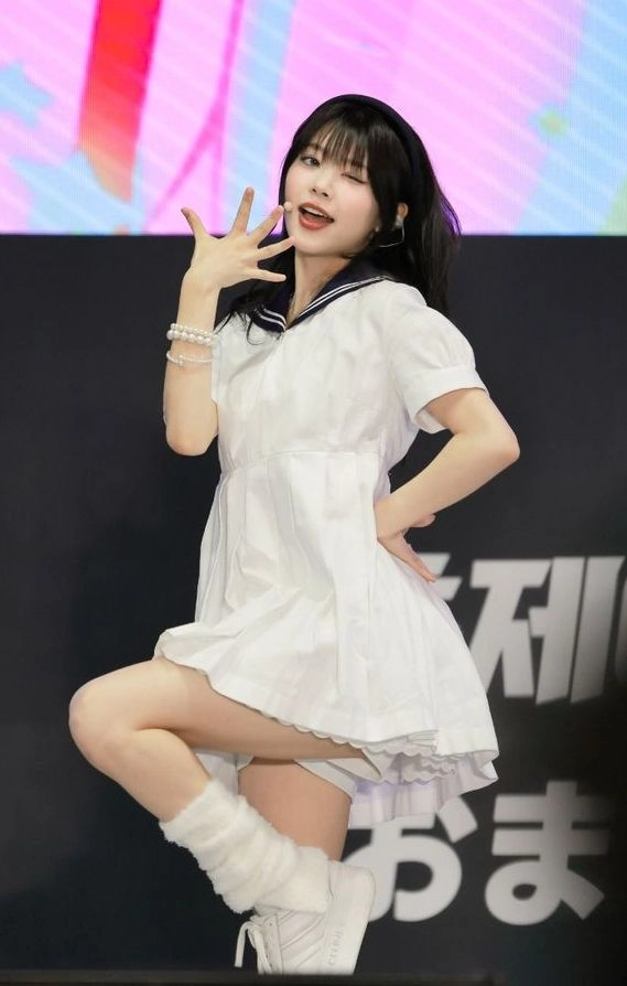 穿着白色裙子和蓝色项链的女人为一张照片。