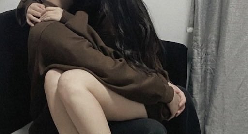 穿着棕色衬衫的女人拥抱自己。