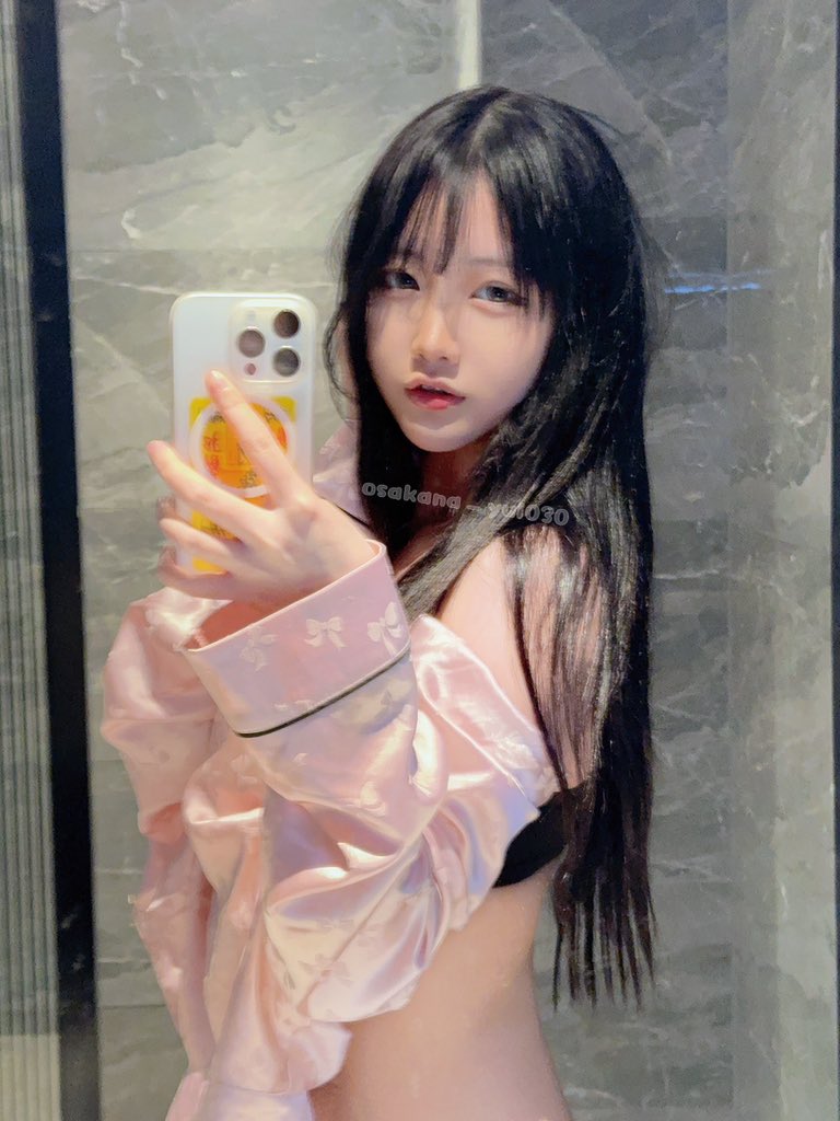 长黑头发和粉红色夹克的女人正在拍照。