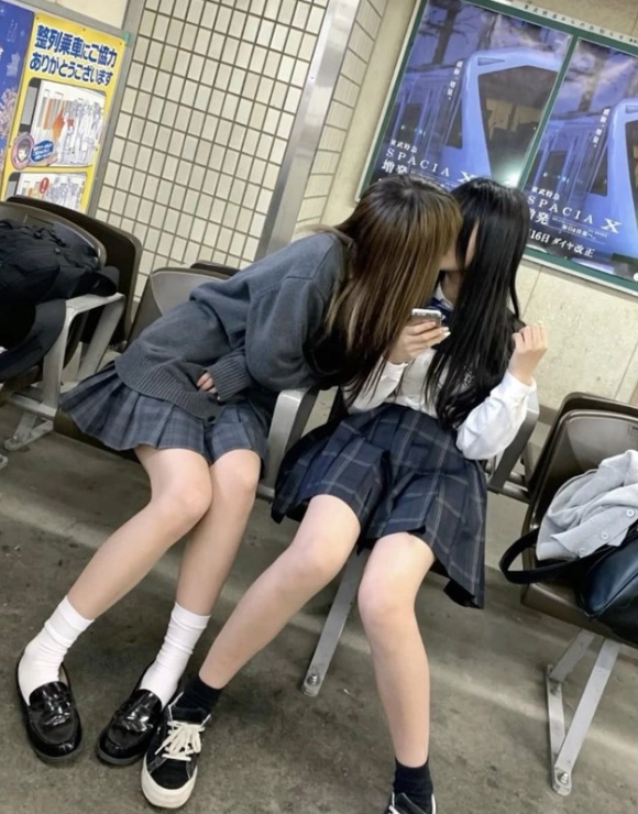 两个女孩在凳子上接吻。