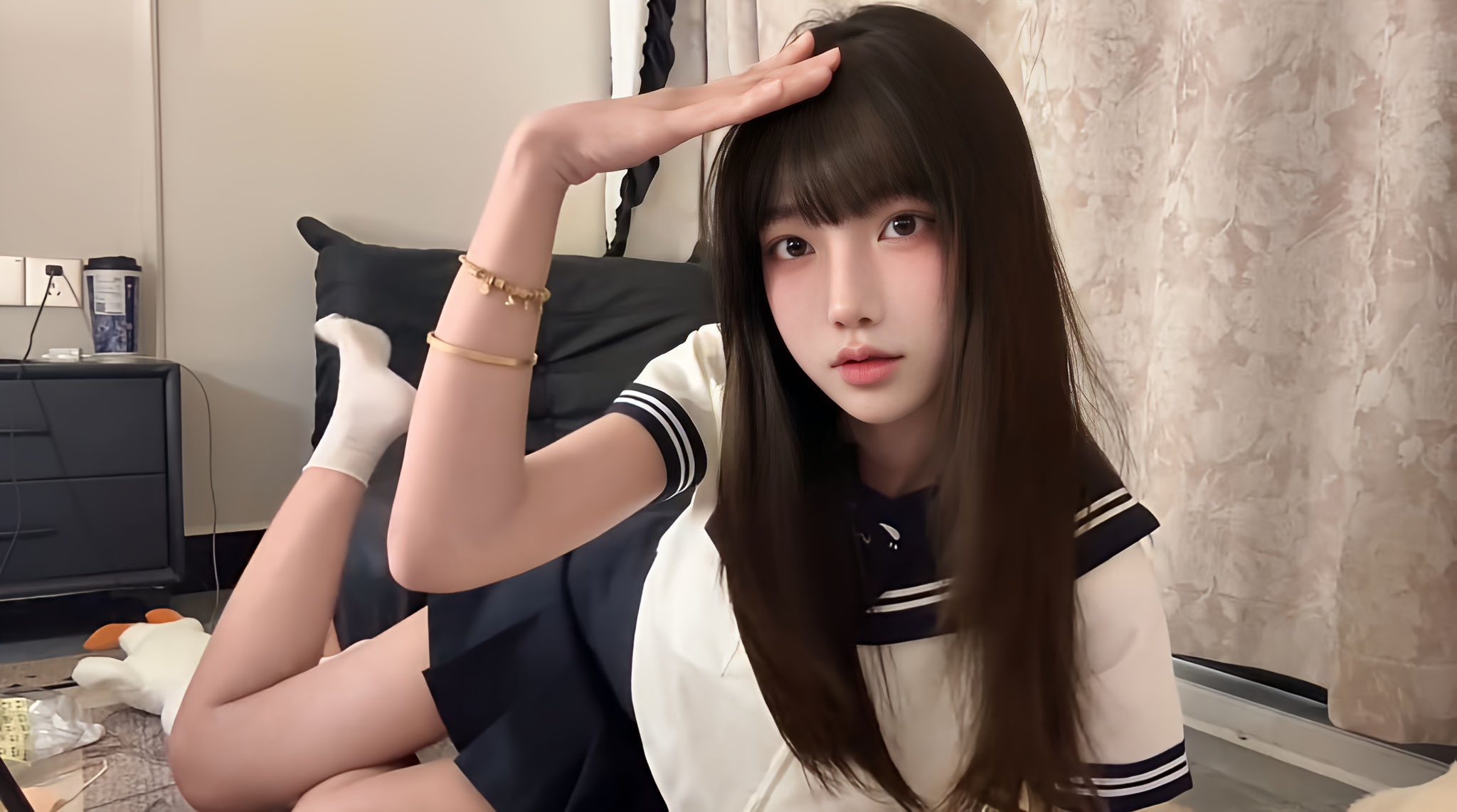 穿着白色衬衫和蓝色领带的女孩用她的手制作心脏形状。