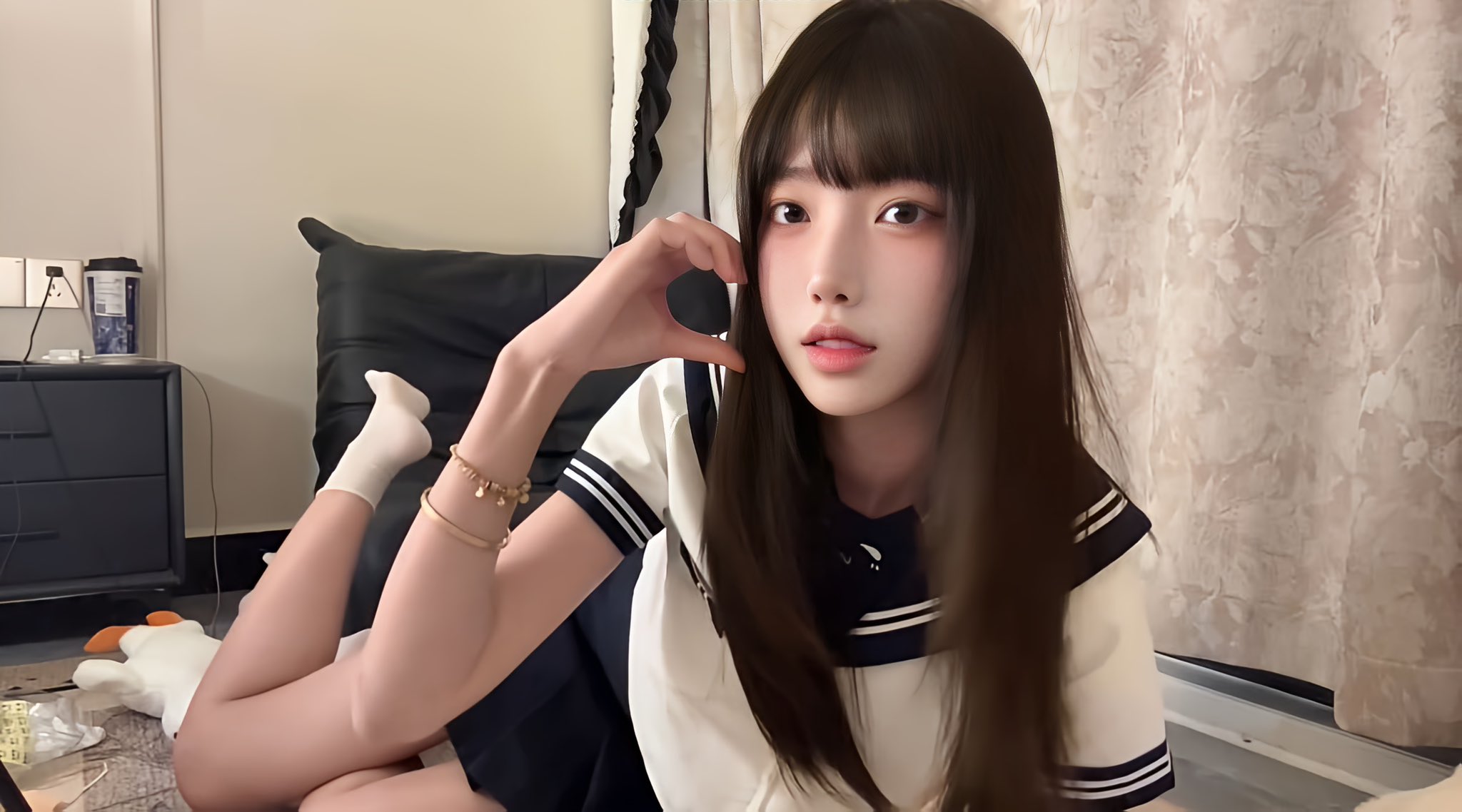 穿着白色衬衫和蓝色领带的女孩用她的手制作心脏形状。