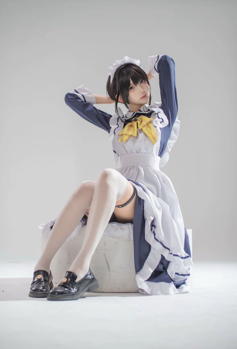 穿着女仆的服装的女人为一张照片。