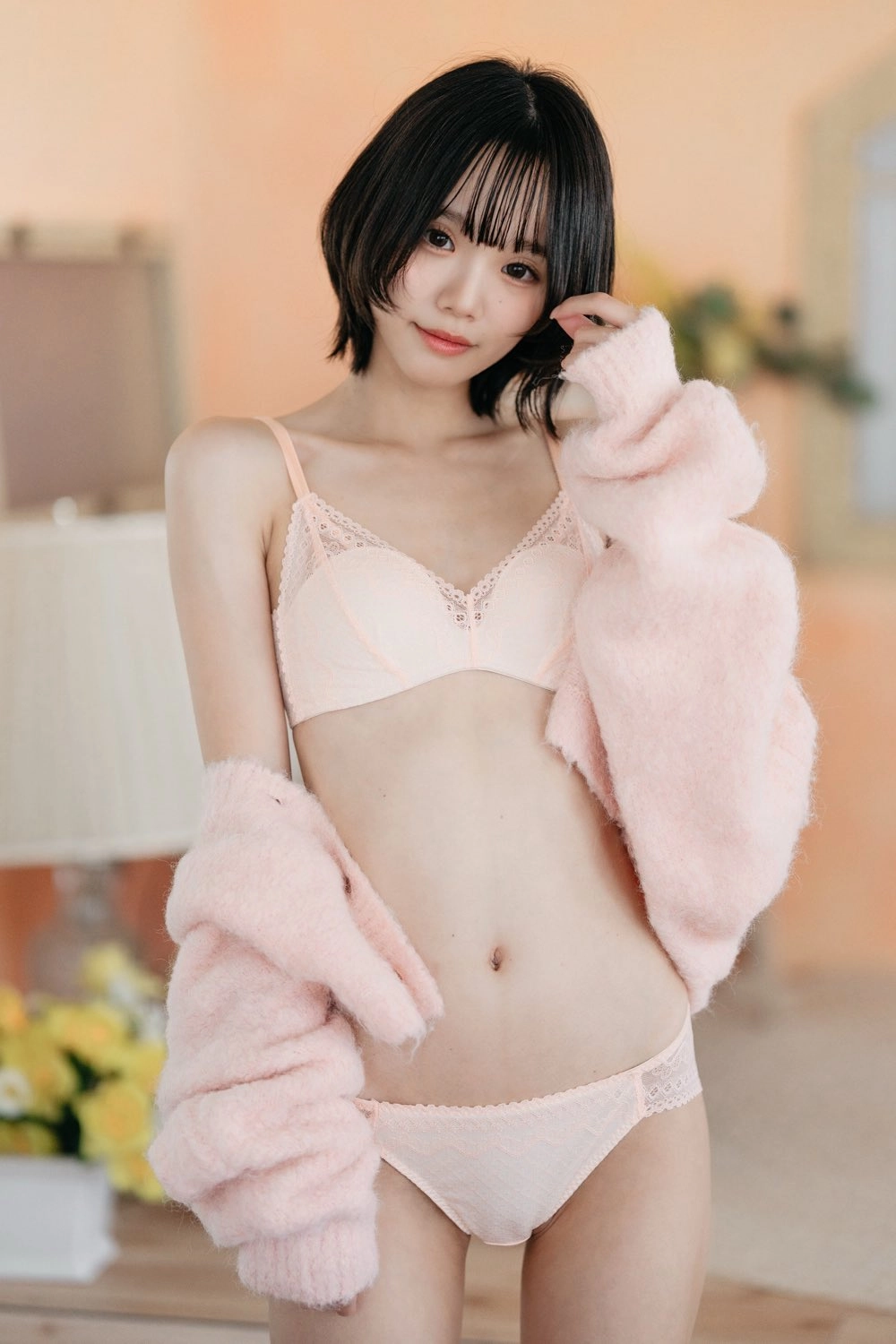 女人穿着粉红色的胸罩和粉红色的夹克。