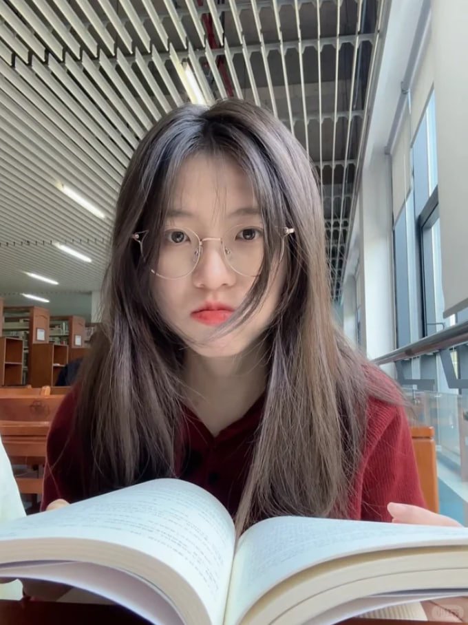 一位戴着眼镜和红色衬衫的女人读了一本书。