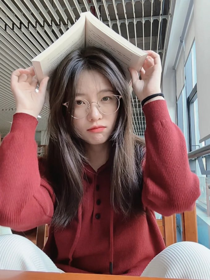 一位戴着眼镜和红色衬衫的女人读了一本书。