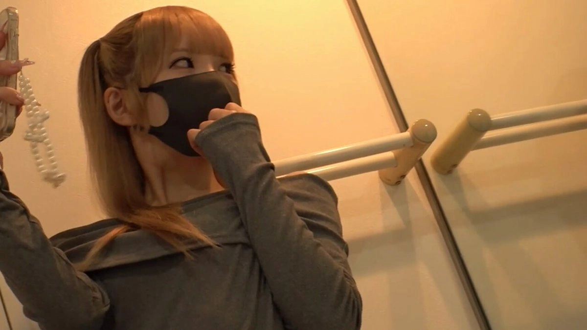 戴着黑面具和灰色衬衫的女人。