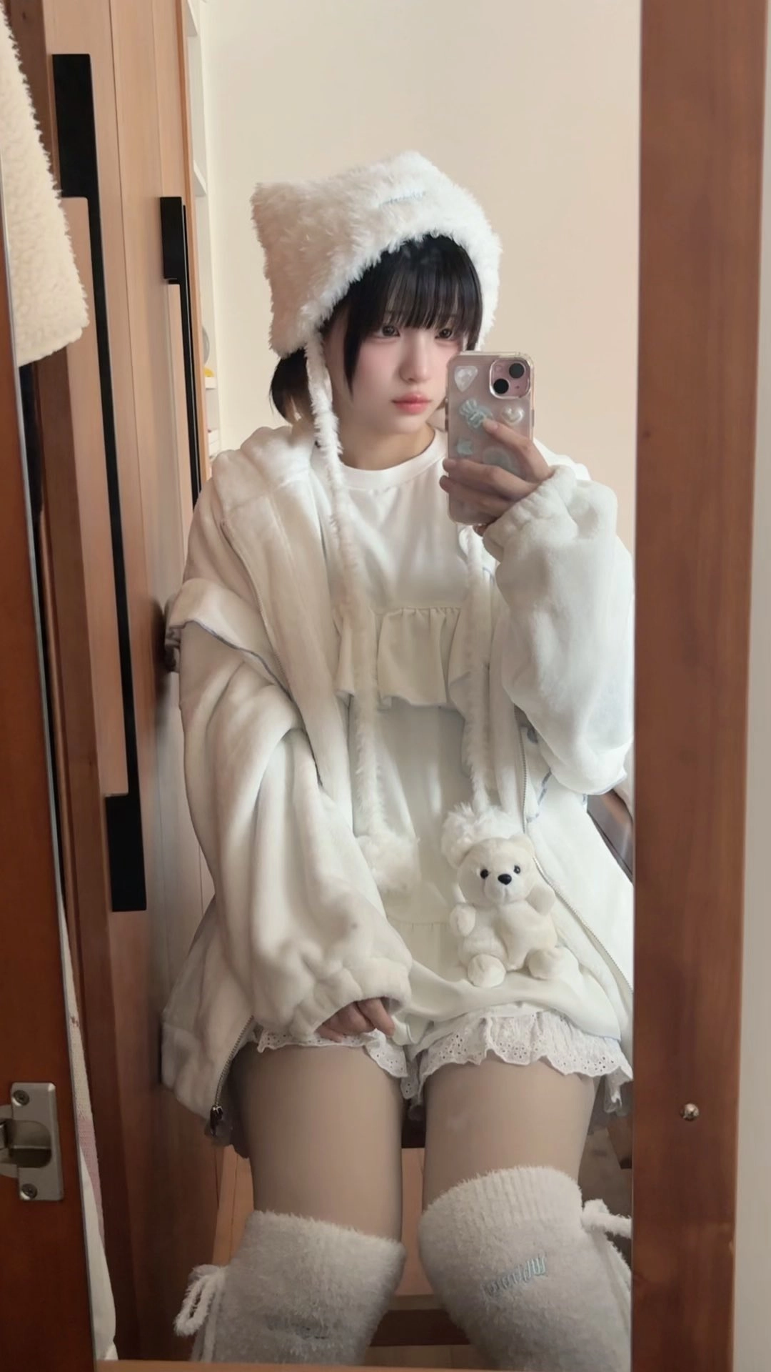 穿着白色外套的女人拿着手机。