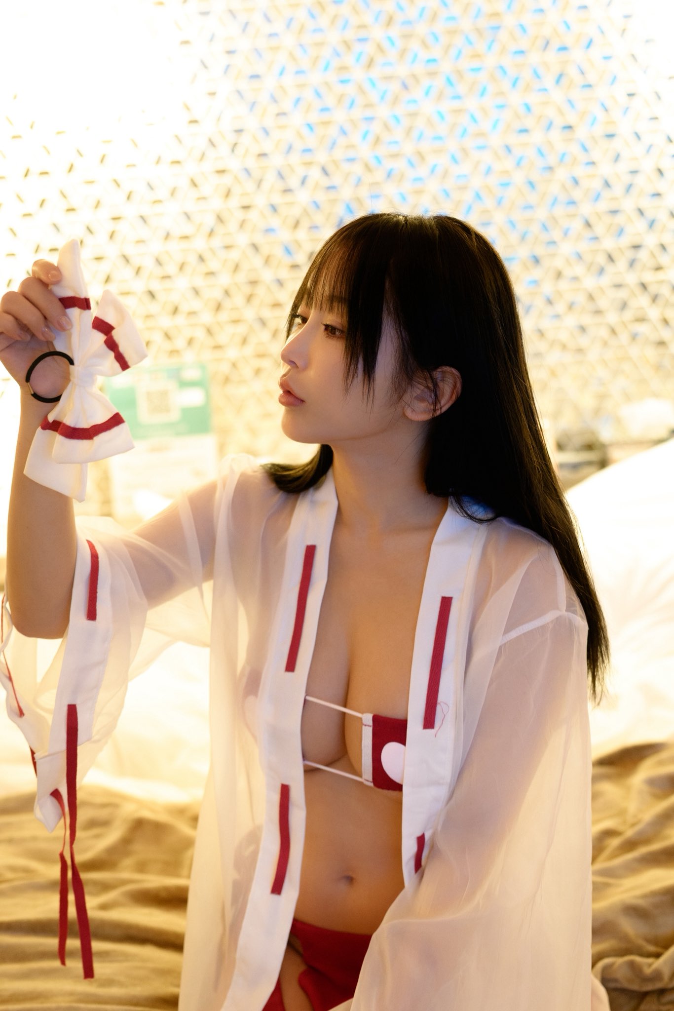 穿着白色衣服的女人拿着一根红色的弓。