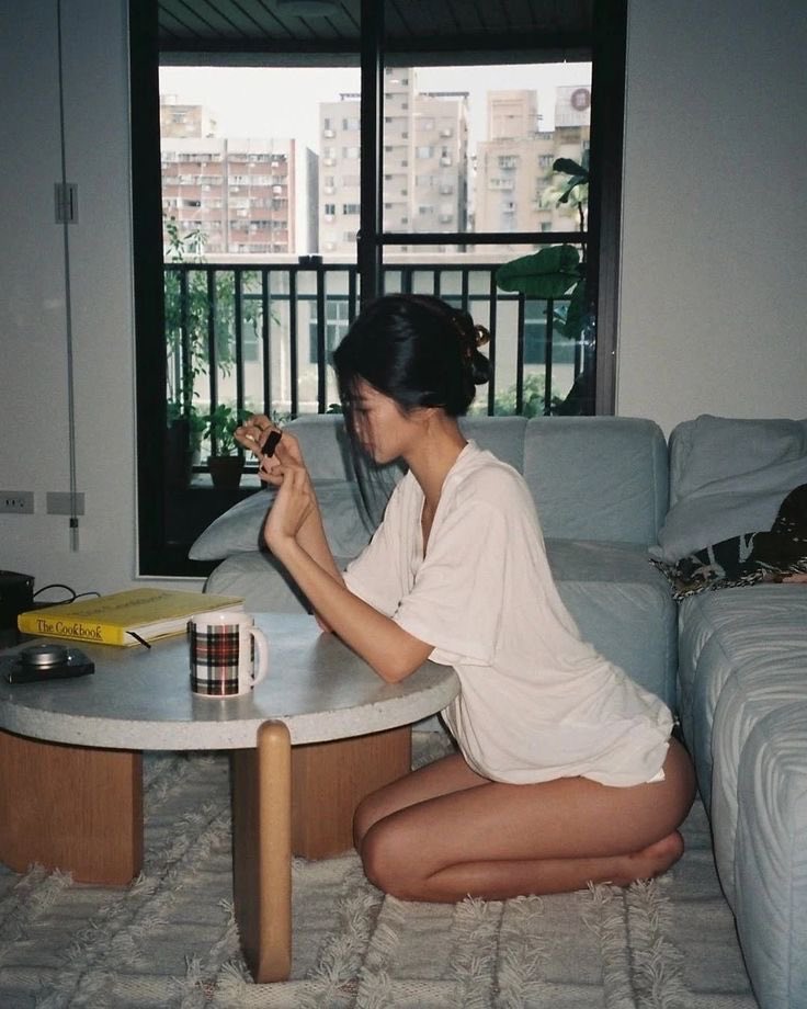 女人坐在沙发上,拿着一杯咖啡。