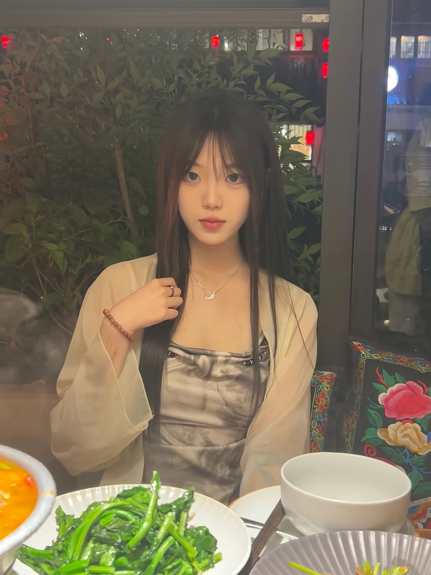 长头发和项链的女人坐在一张桌子上。