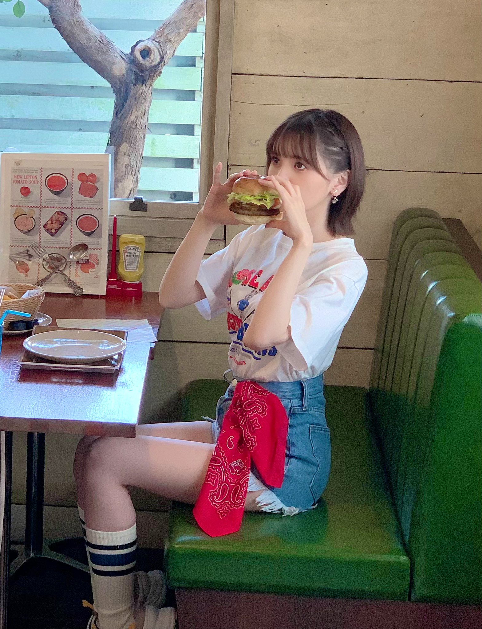 穿白衬衫的女人吃了一顿三明治。