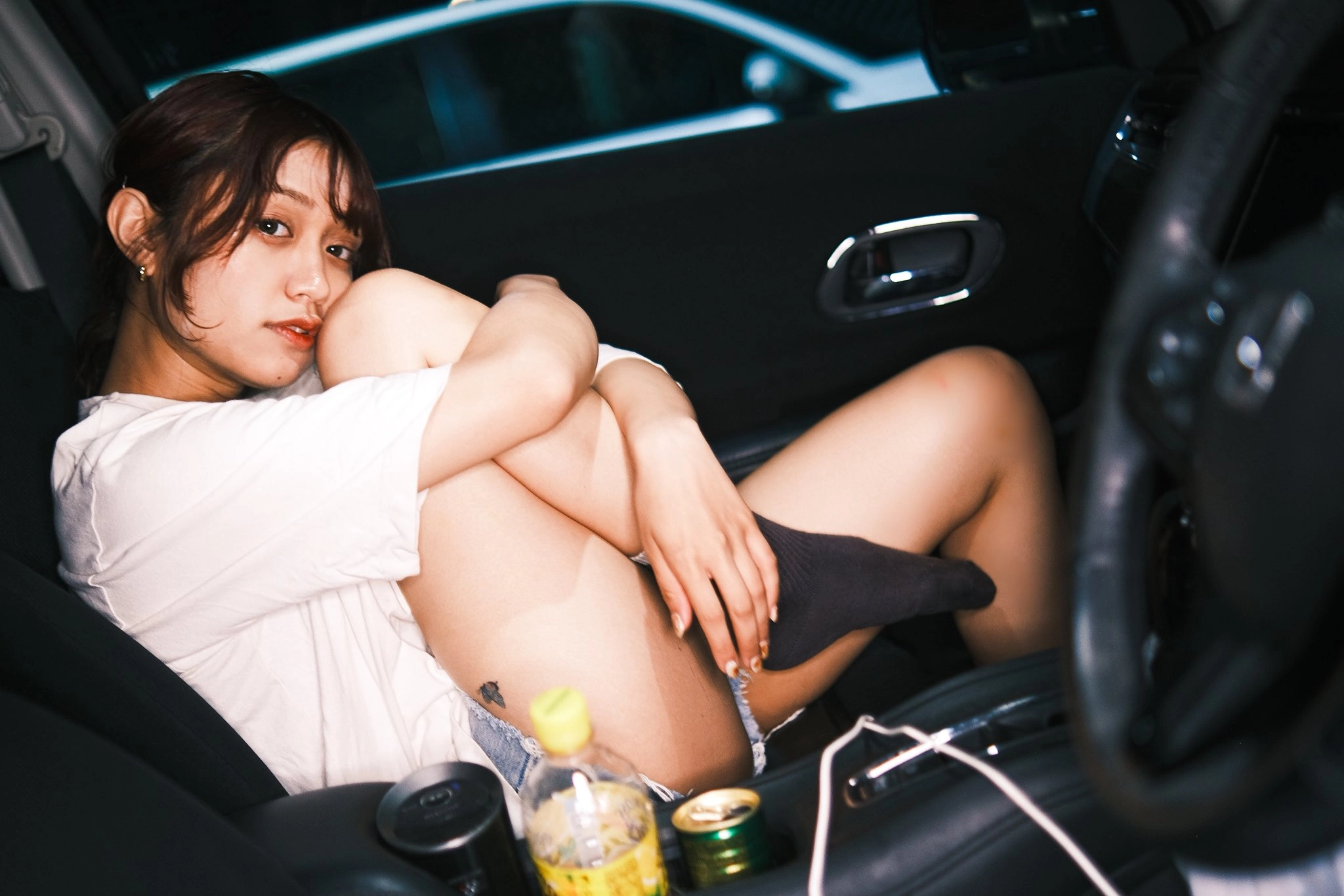 女人坐在一辆车里,带着一瓶果汁。